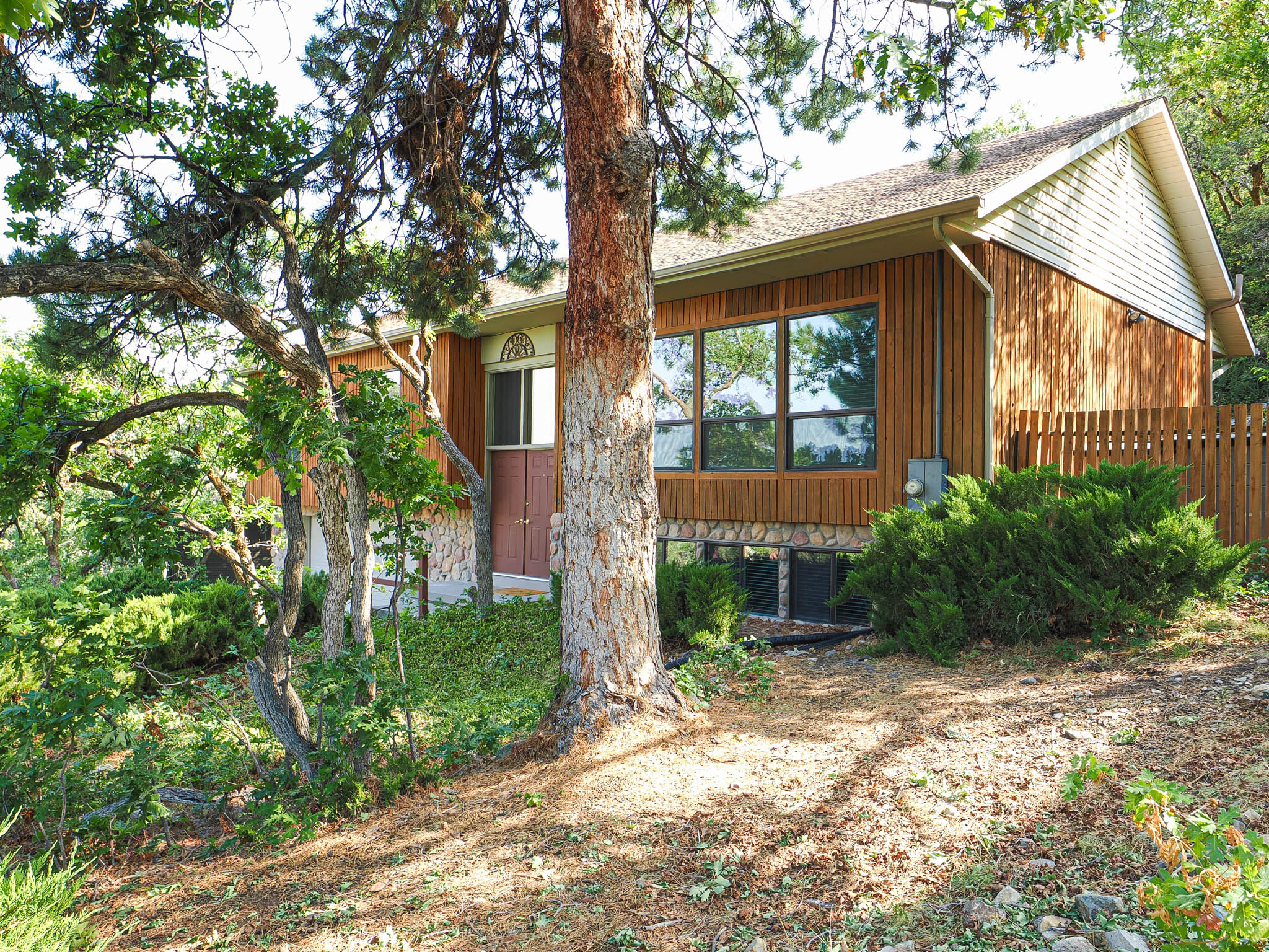 Wood-sided exterior featuring a gabled roofline and a stone foundation