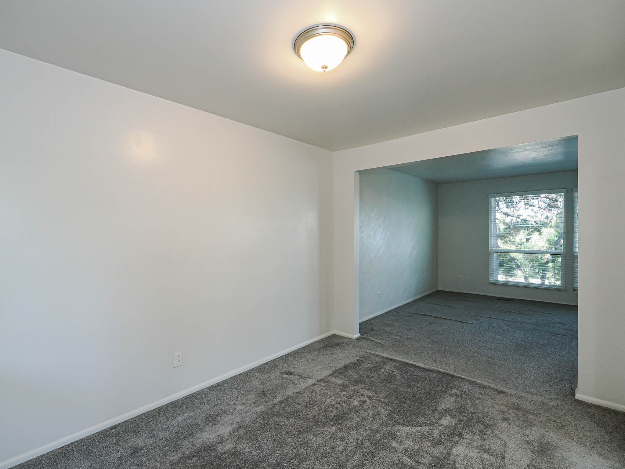 Interior room with neutral wall finishes and gray carpeting