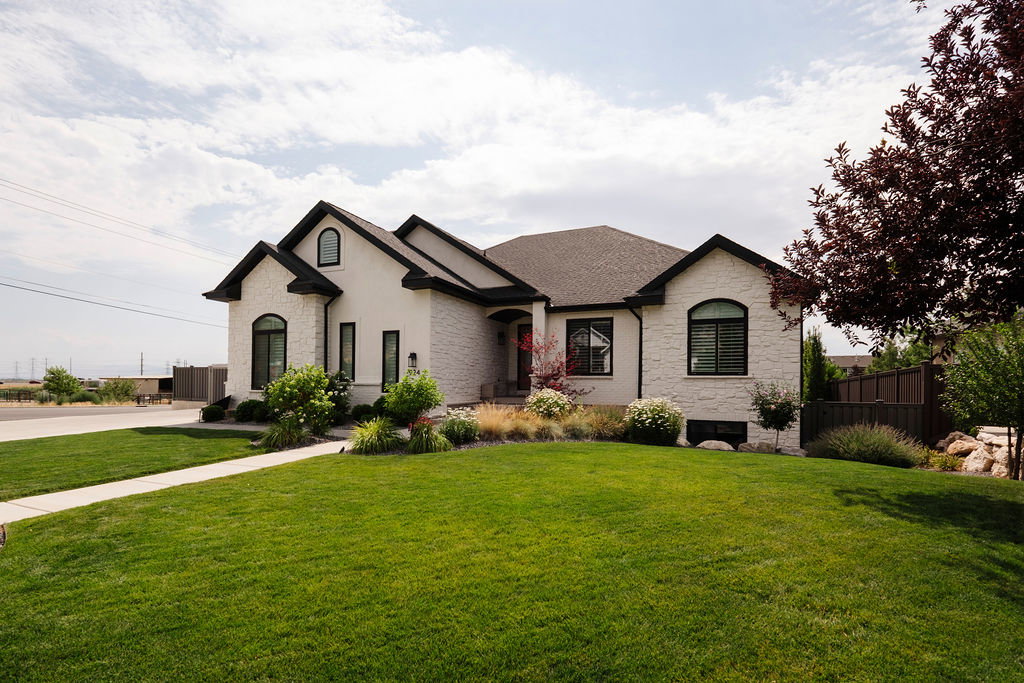 Contemporary residence featuring light-colored stone and stucco exterior with dark trim accents