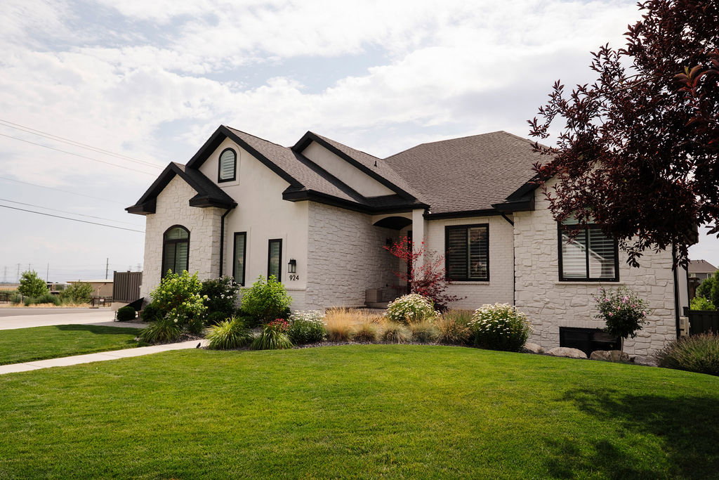 Contemporary residence featuring a white stone and stucco exterior with dark trim