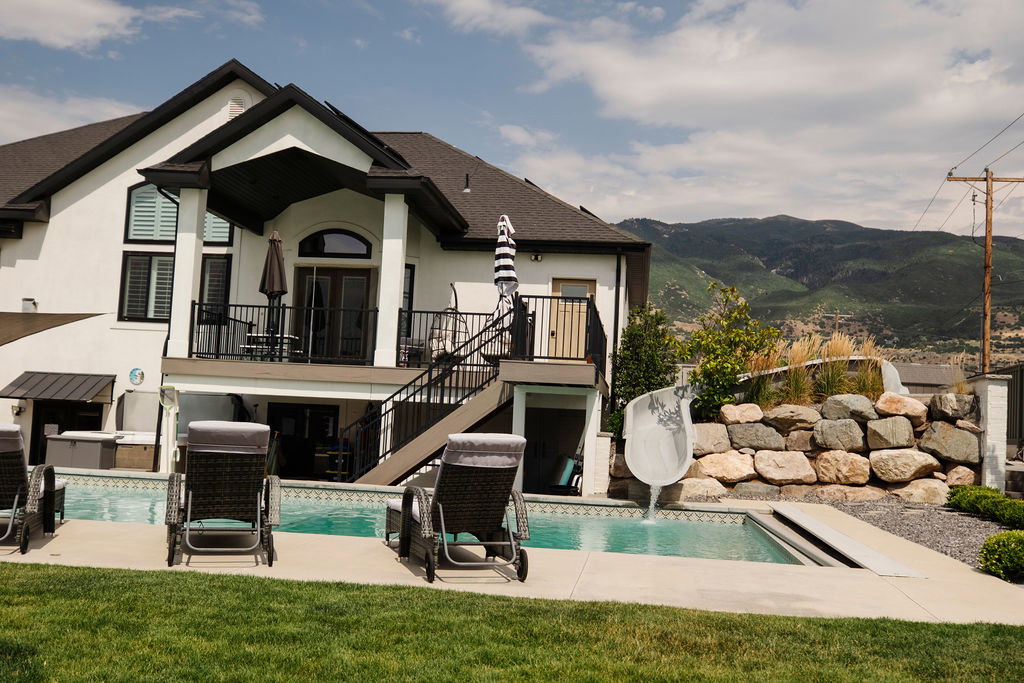Rear exterior featuring a multi-level design with a built-in pool and integrated water slide