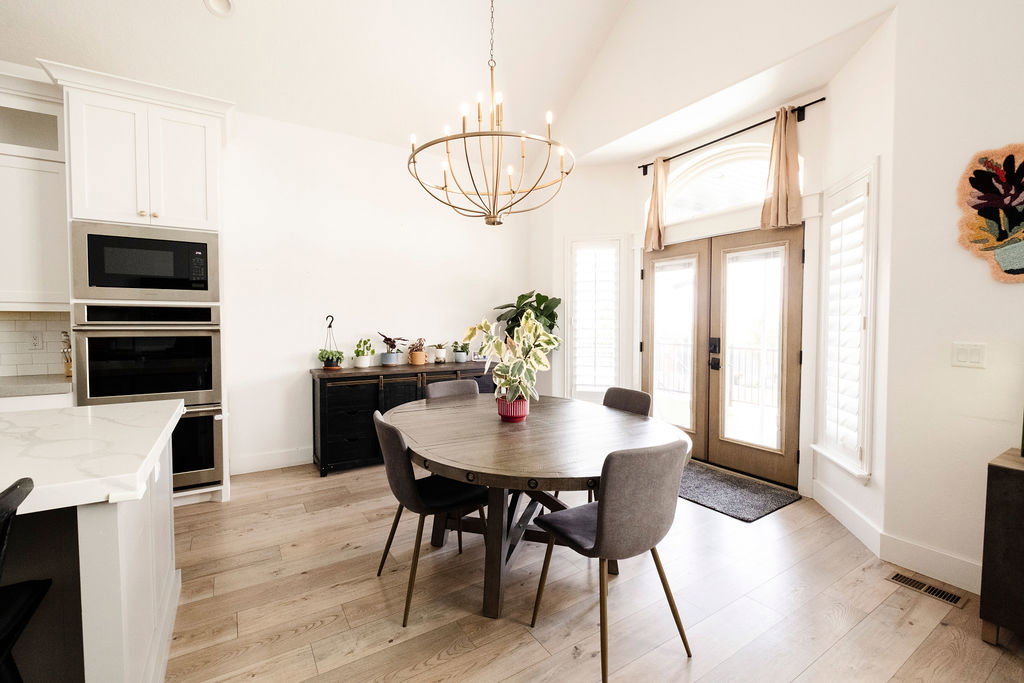 Open-concept dining area featuring a vaulted ceiling and a decorative chandelier