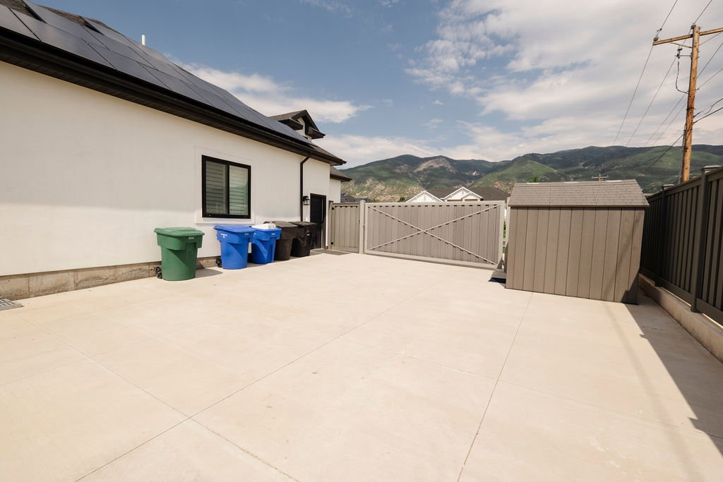 Spacious concrete patio area featuring a privacy fence and gate