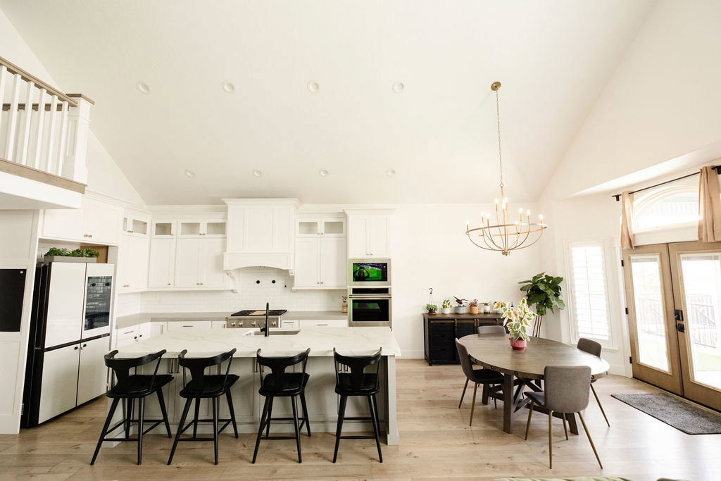 Expansive open-concept kitchen and dining area featuring vaulted ceilings with recessed lighting
