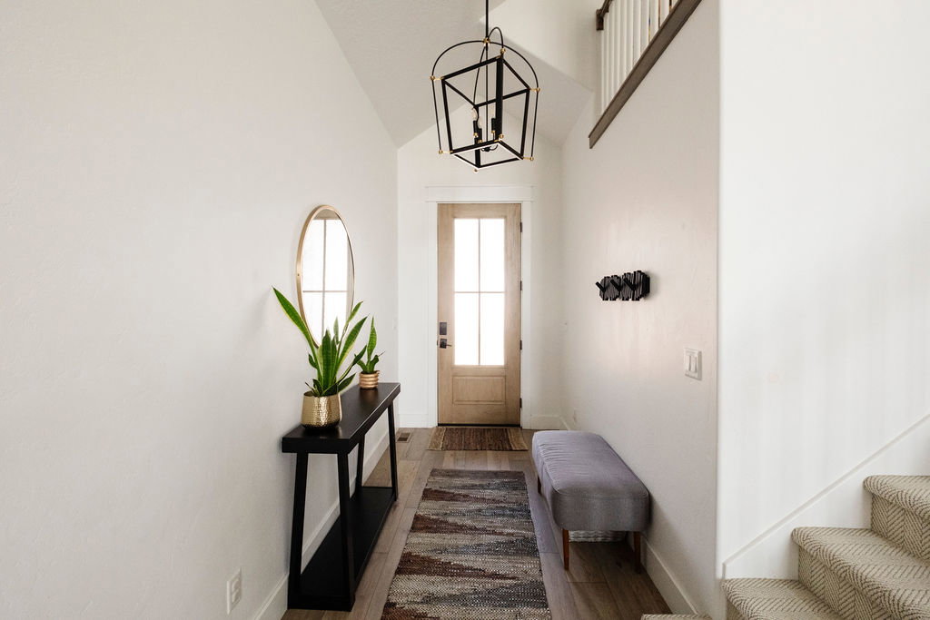 Entryway featuring a natural wood-finish door with glass panels, high vaulted ceilings, and wood-finish flooring