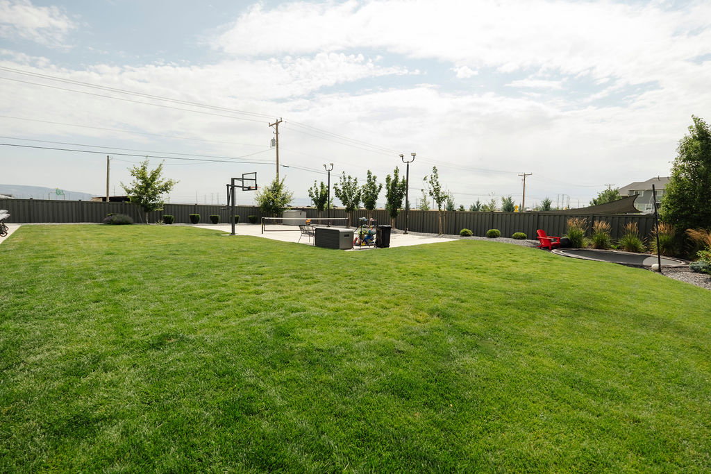 Expansive green lawn with a perimeter fence
