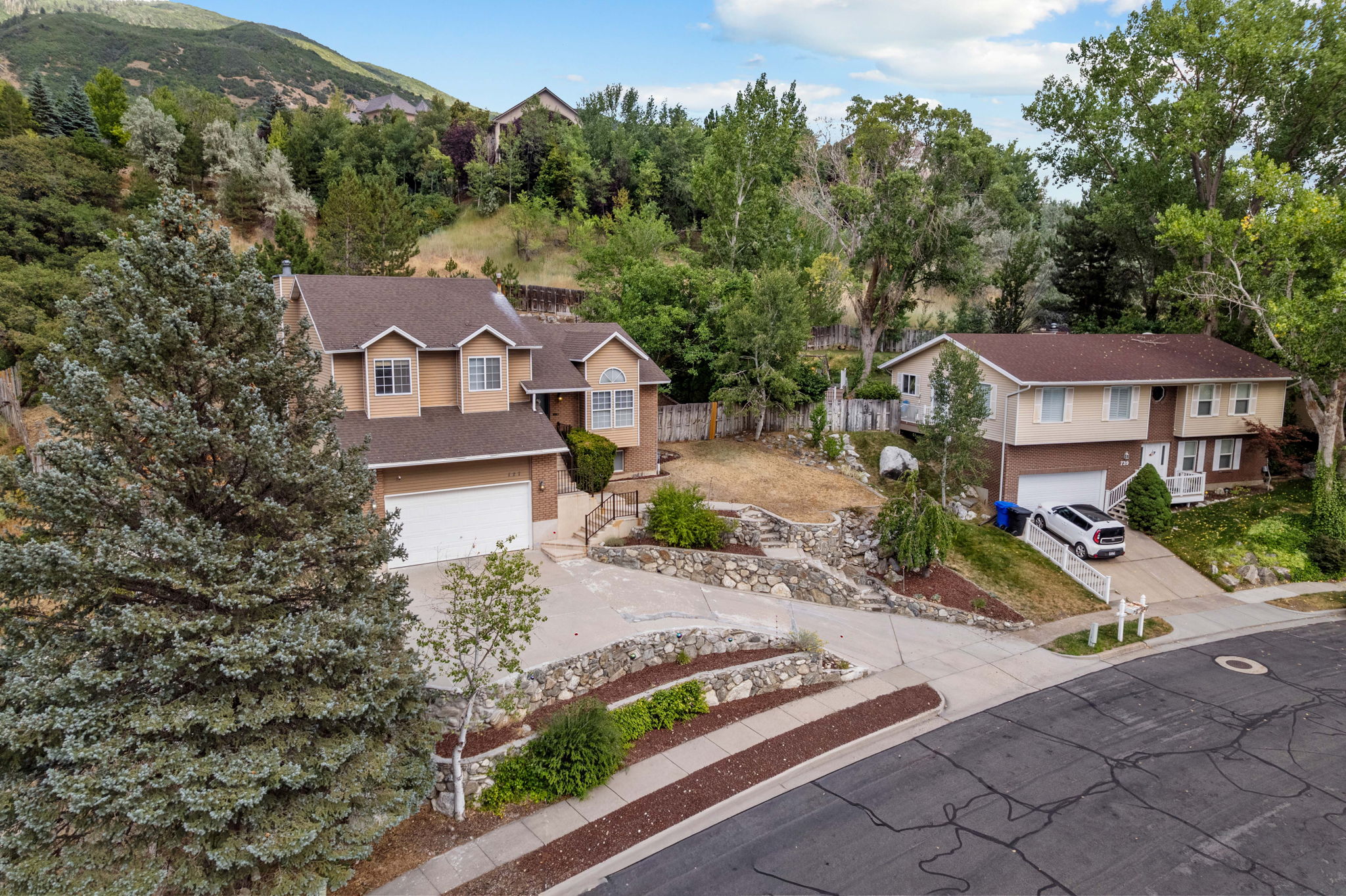 Multi-level residence featuring a two-car garage, pitched roofline, and dormer windows