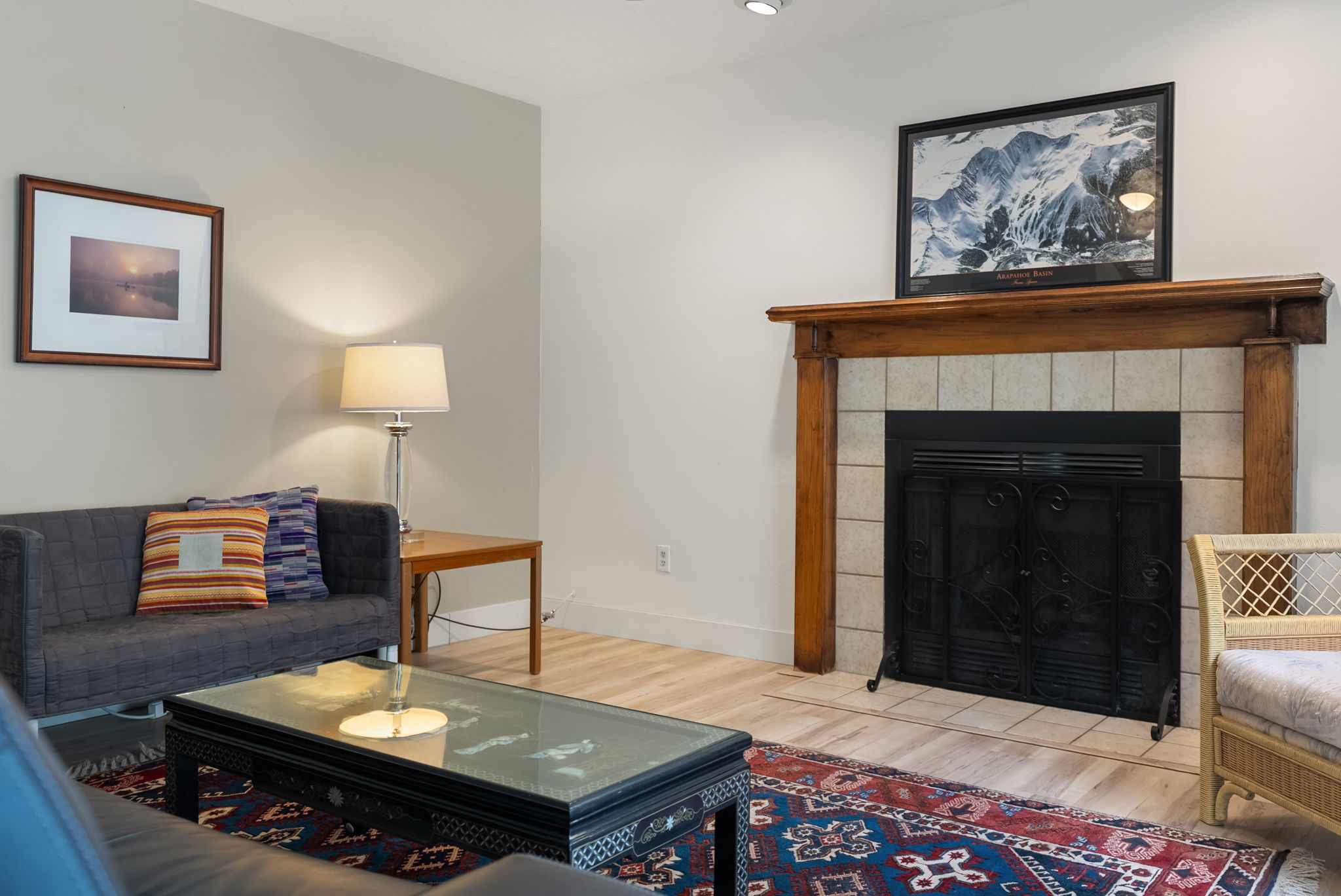 Fireplace featuring a wood mantel, tile surround, and black metal screen