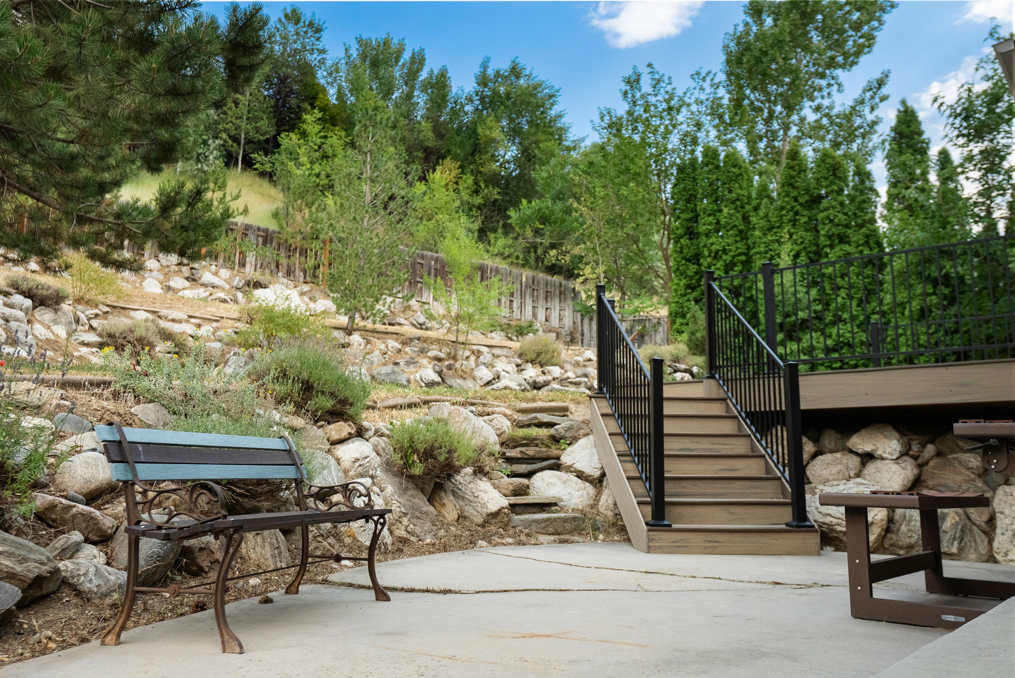 Tiered landscaping with natural stone retaining walls and mature greenery