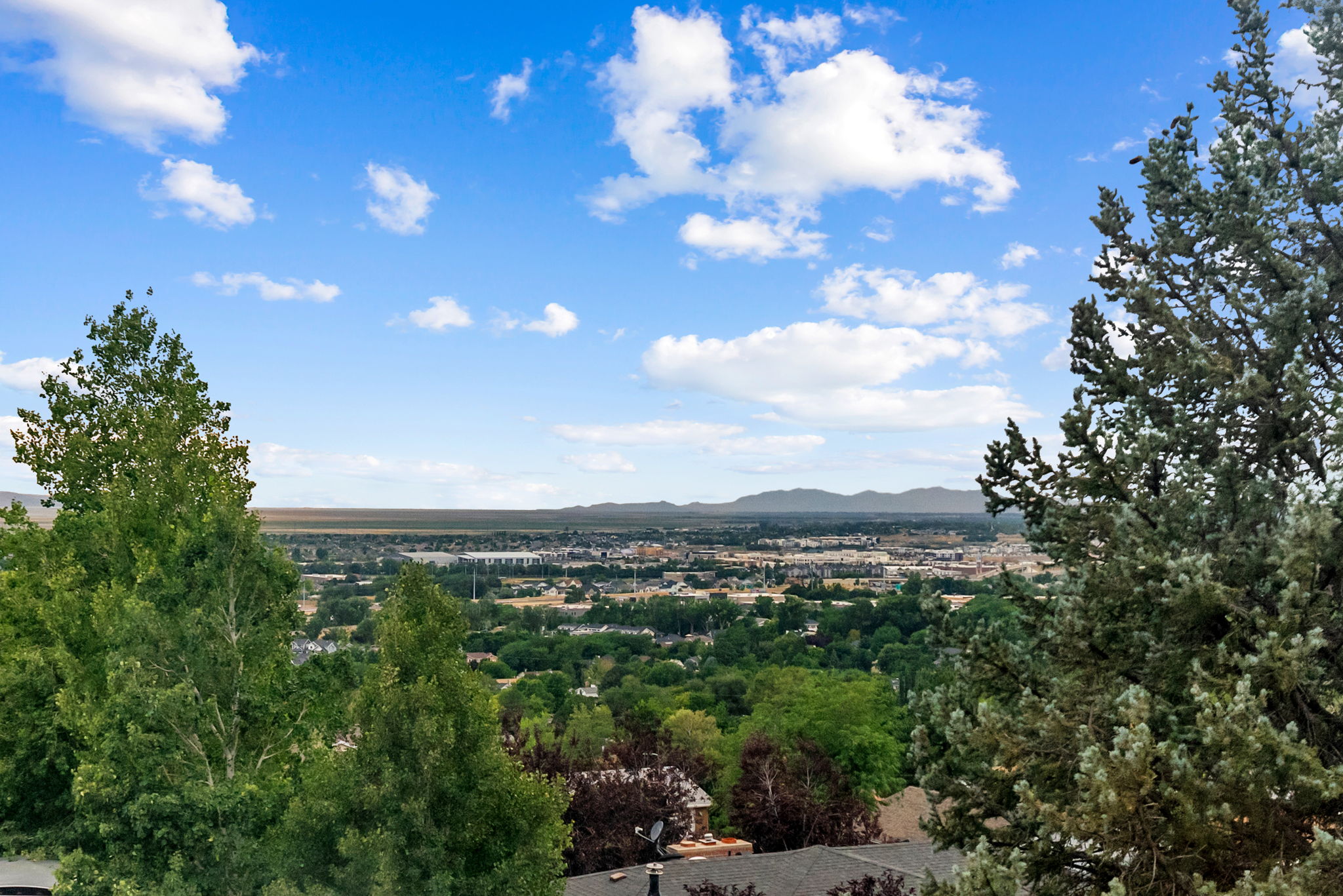 Expansive panoramic scenery featuring distant mountains and a developed residential area