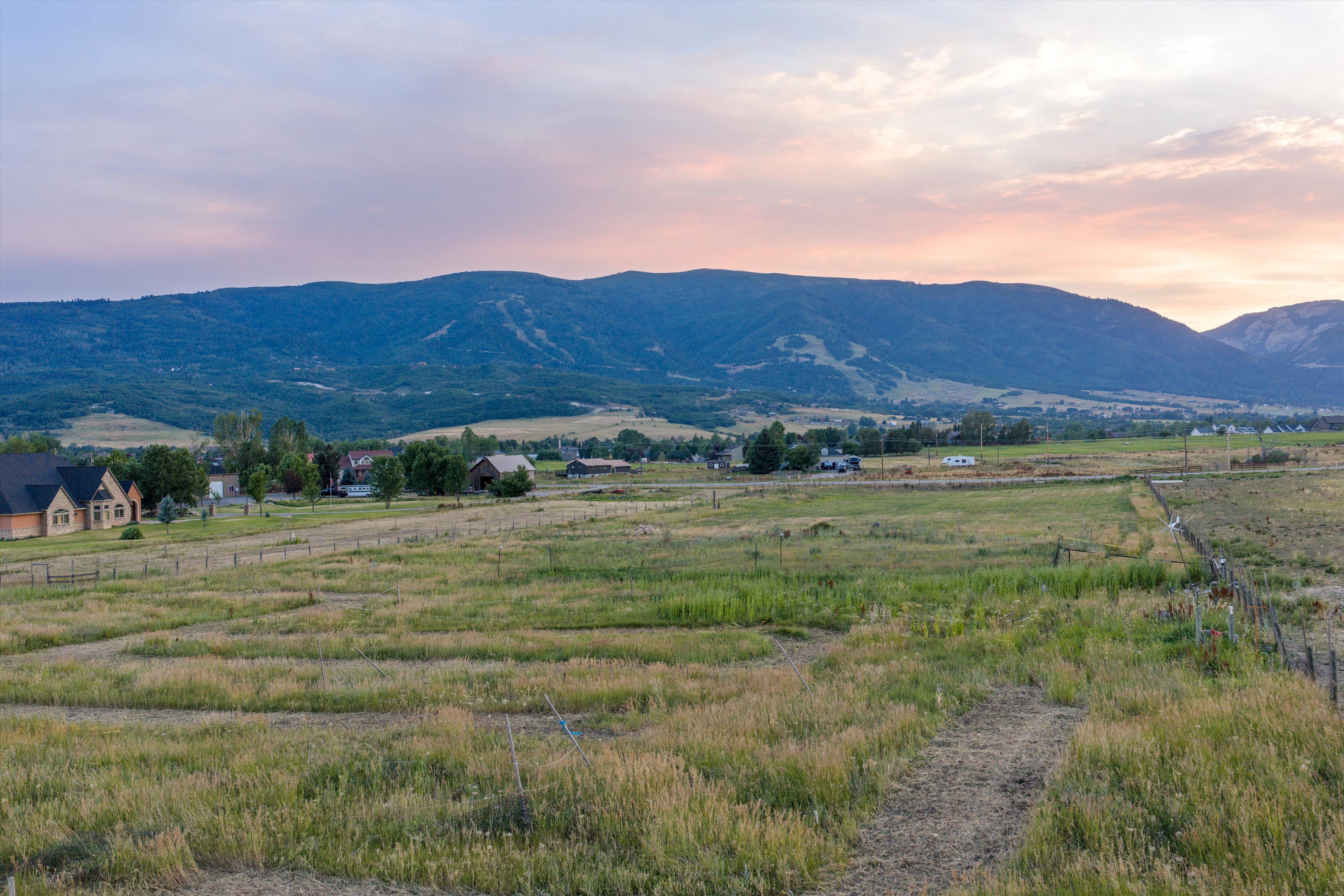 Expansive undeveloped land featuring natural grasses and distant mountain formations