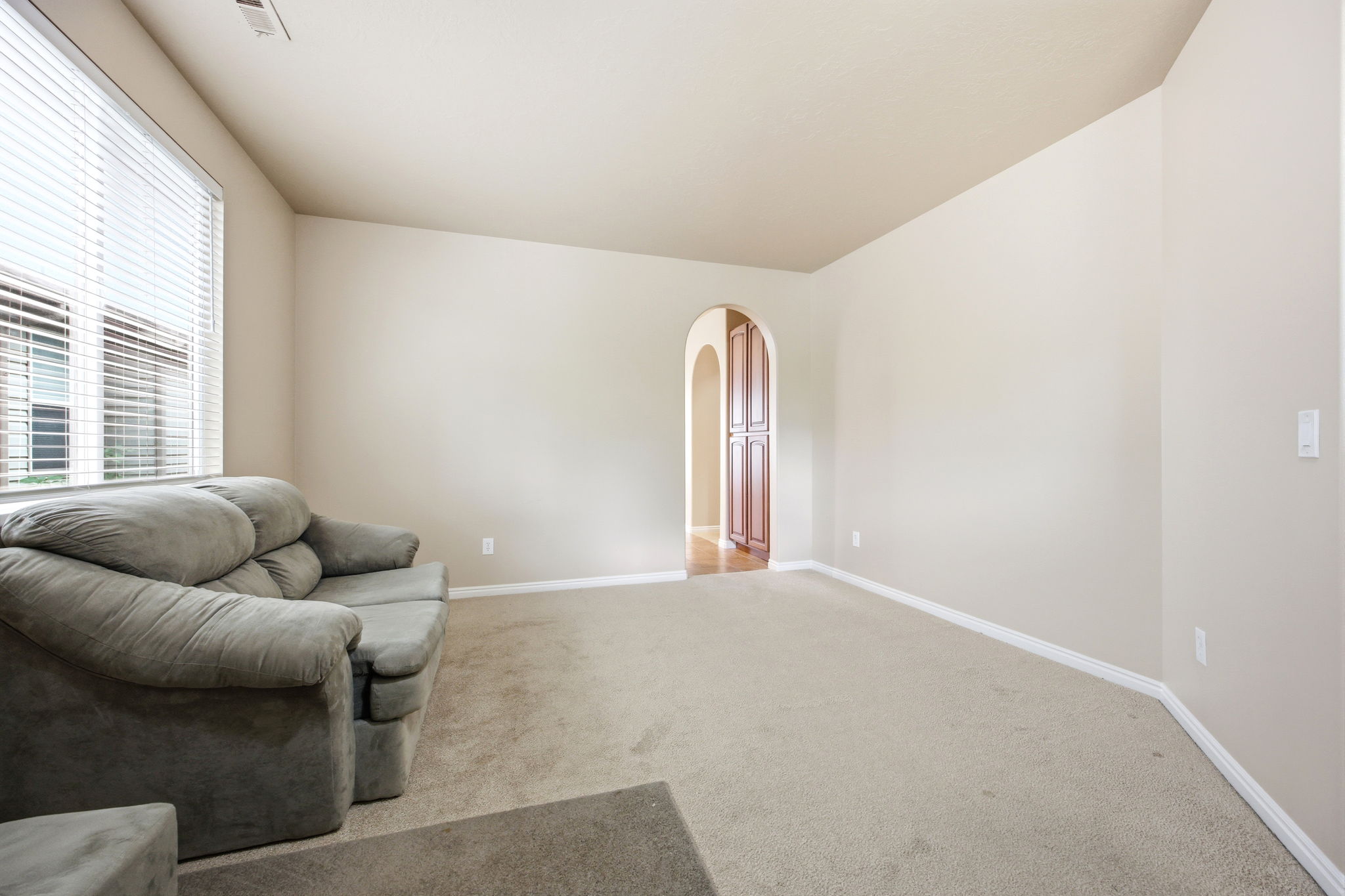 Spacious living area featuring neutral carpeting and light-toned walls