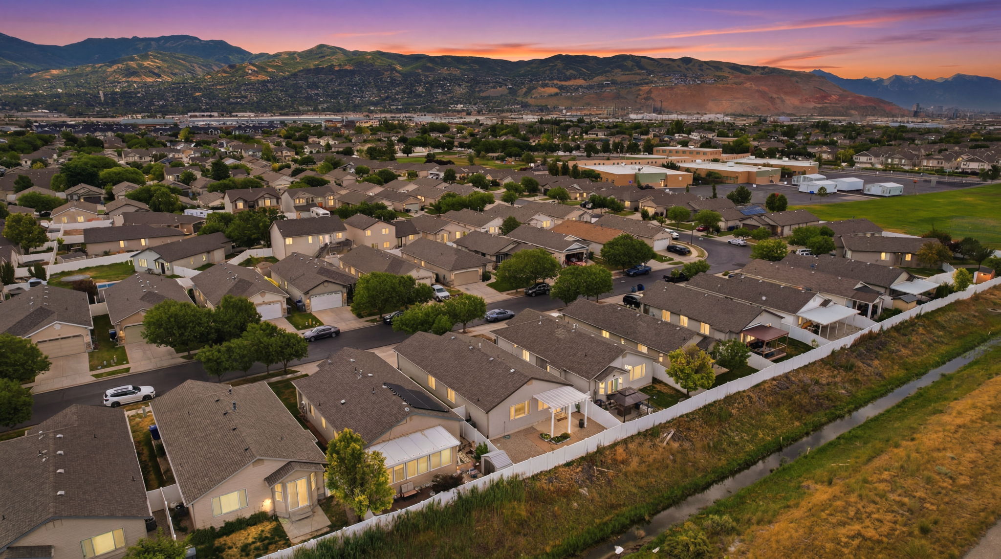 Aerial perspective of a residential neighborhood featuring numerous single-family homes with gray shingle roofs