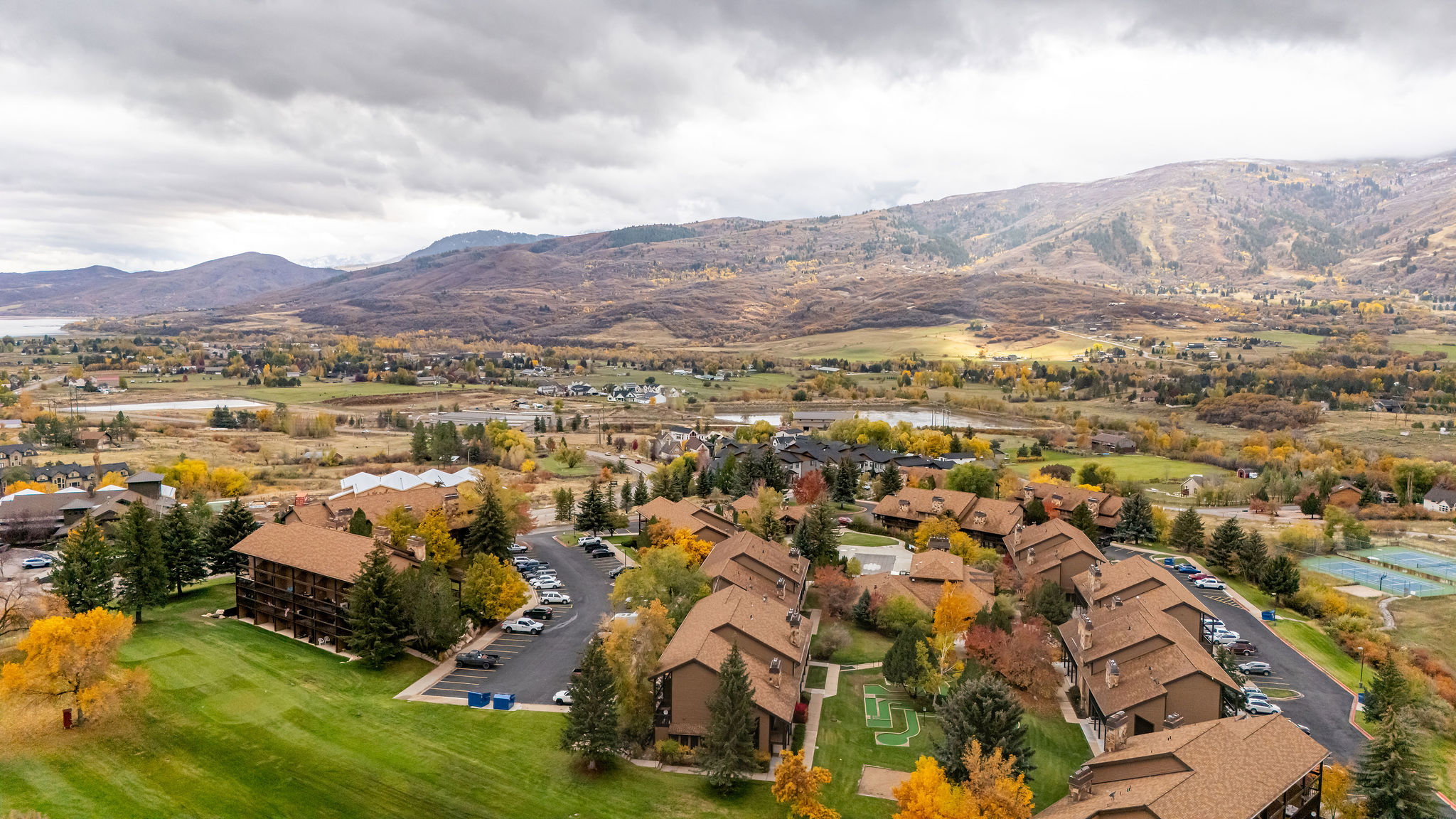 Expansive aerial showcasing a residential community with brown-toned buildings and complementary earth-toned roofs