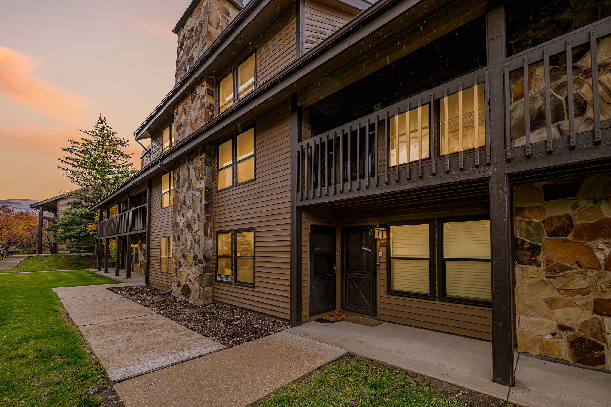 Brown horizontal siding exterior with stone accents and multiple balconies