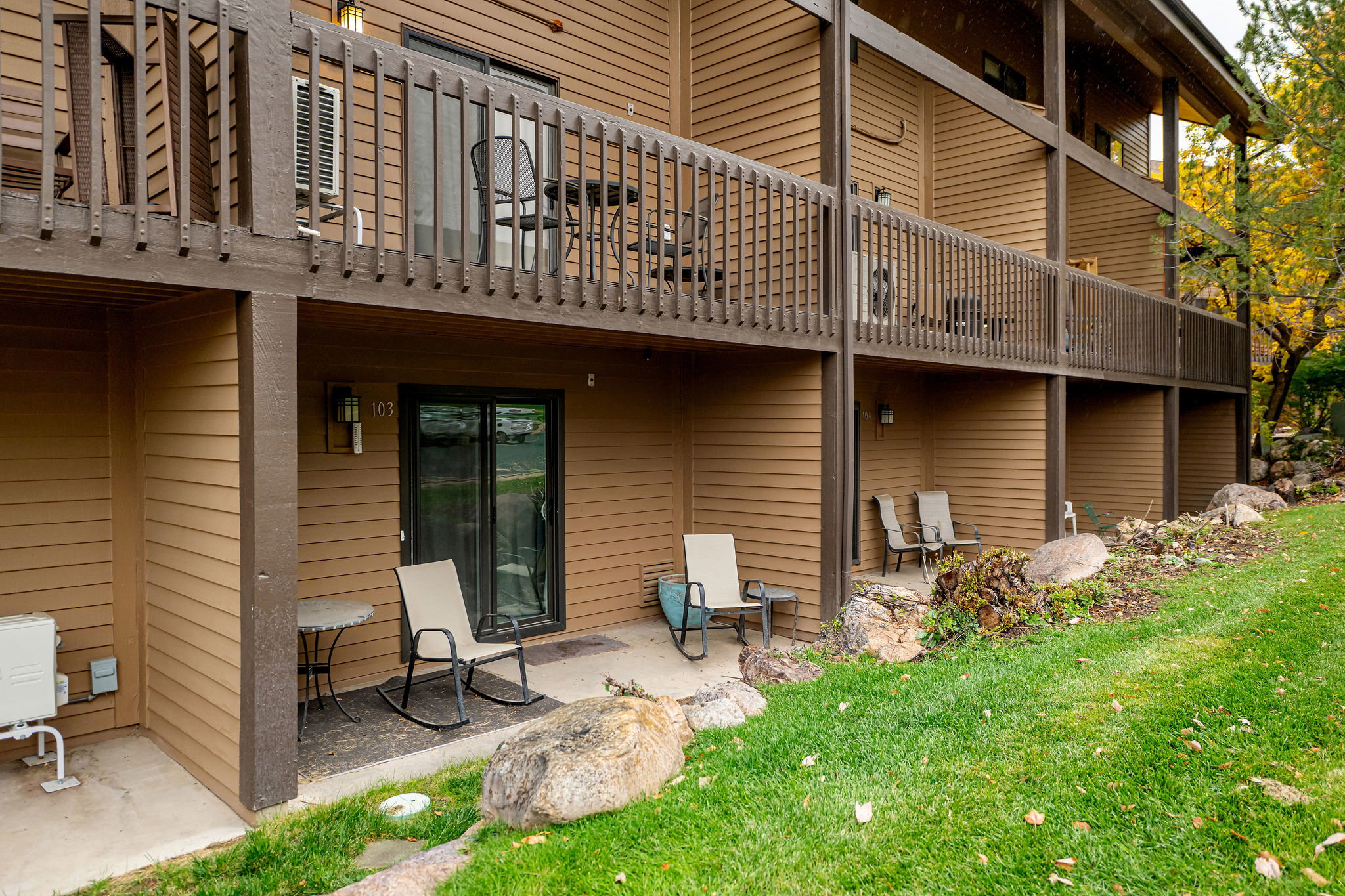 Multi-level condominium building featuring horizontal siding and dark wood-tone railings