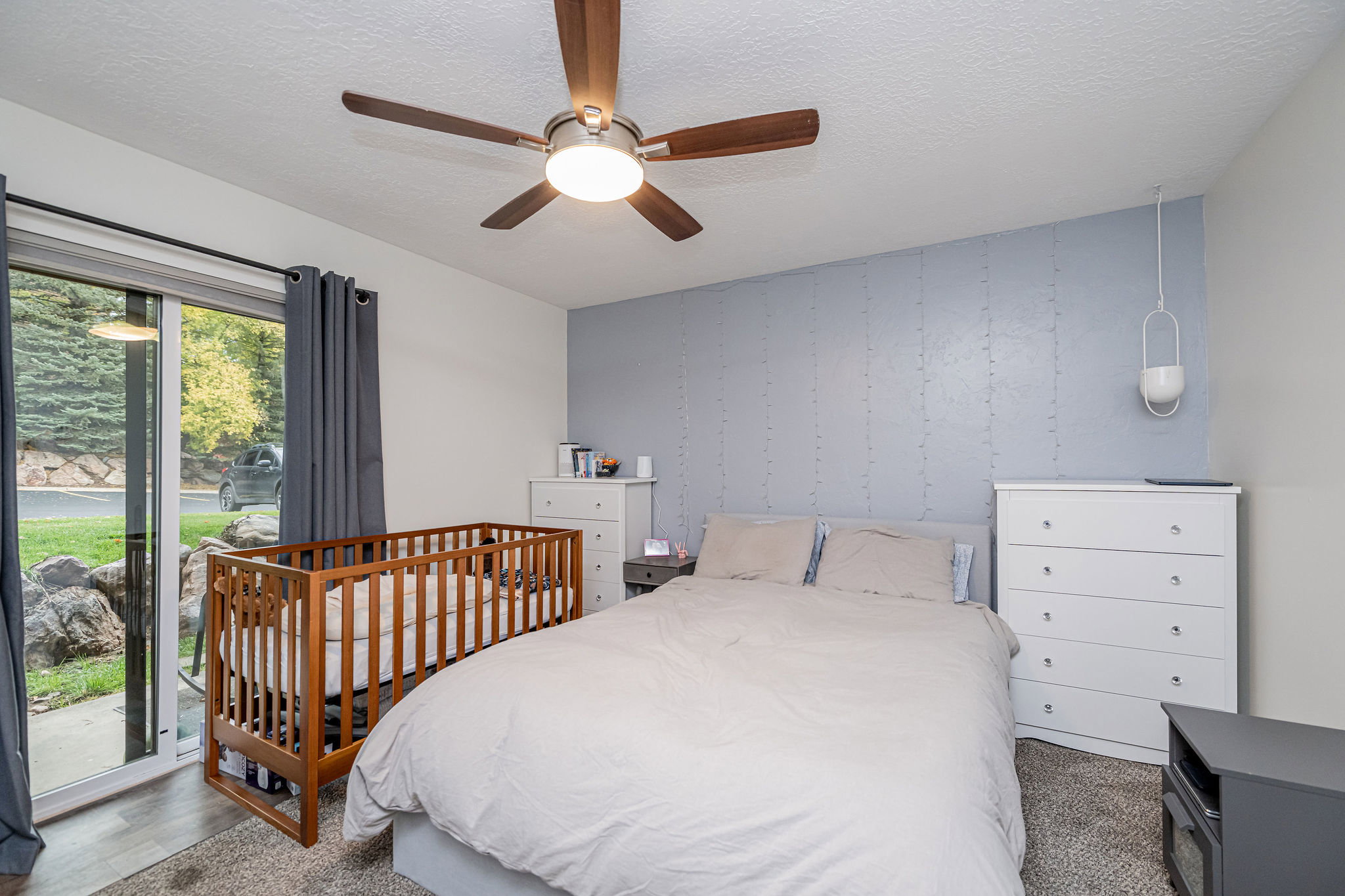 Spacious room featuring wood-finish flooring and a textured accent wall