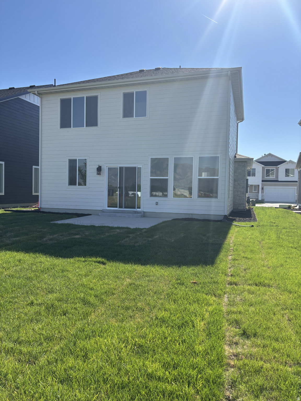 Expansive green lawn with a concrete patio