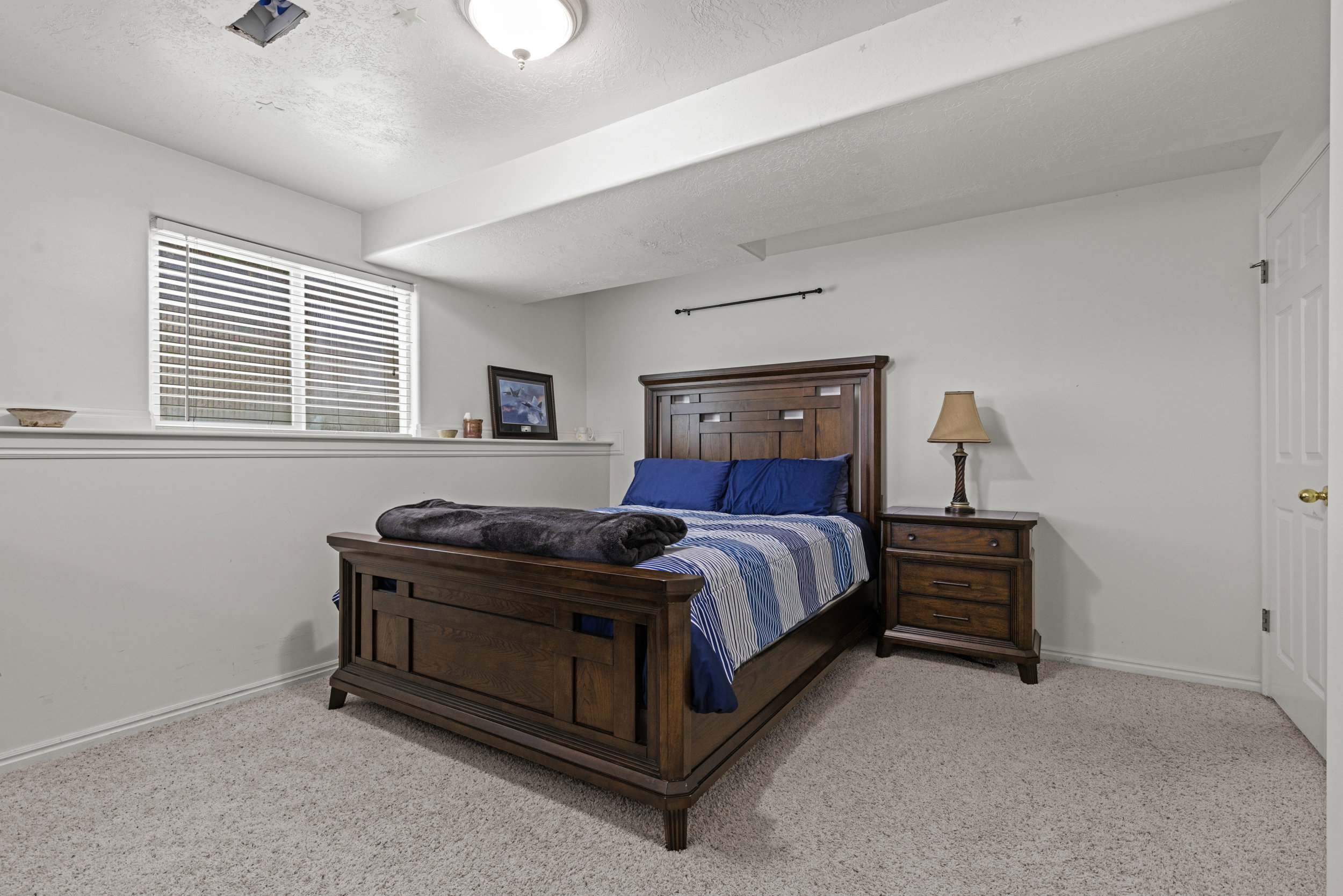 Carpeted room featuring a window with blinds, white trim, recessed lighting, and a white interior door