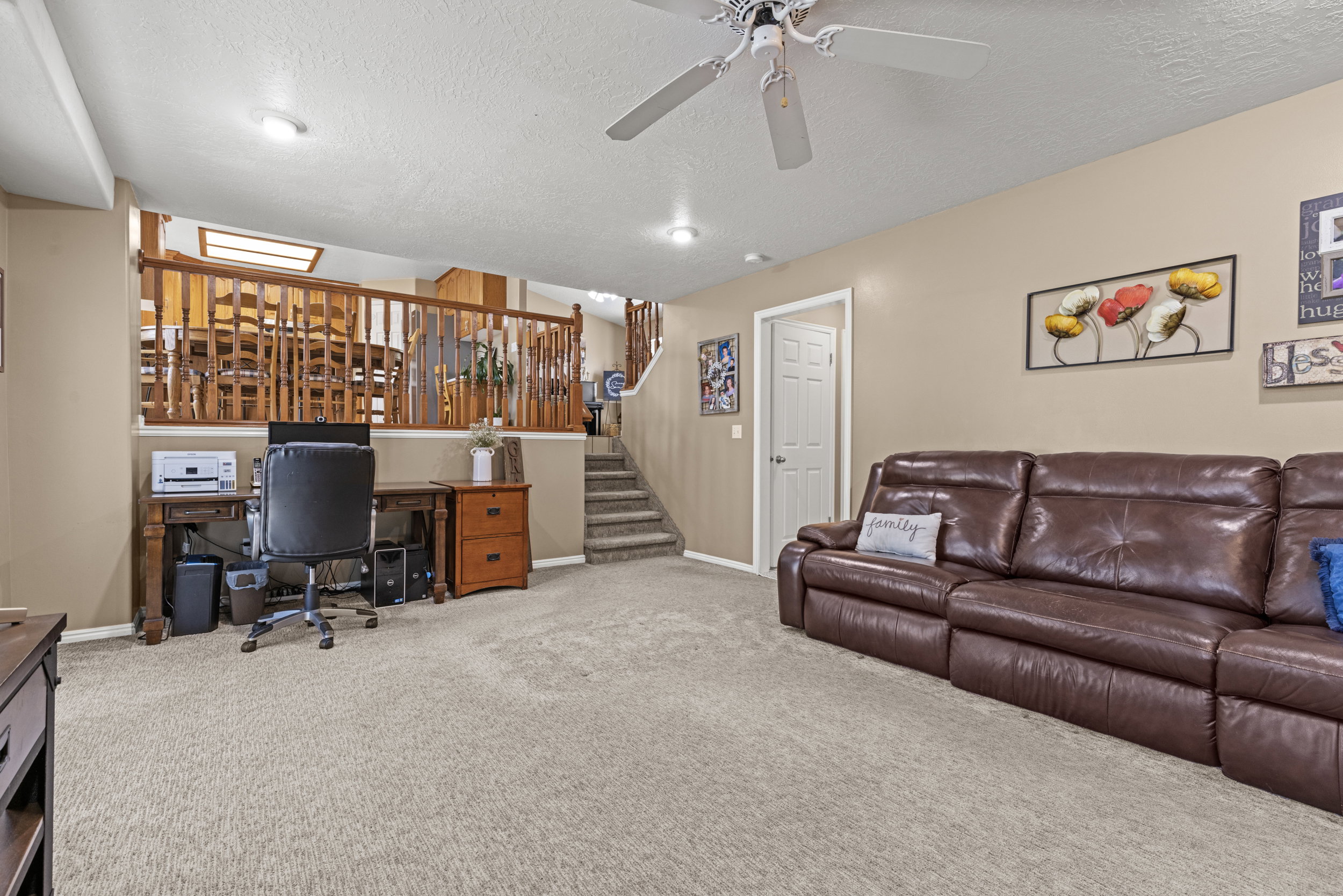 Open-concept lower level with plush carpeting and recessed lighting
