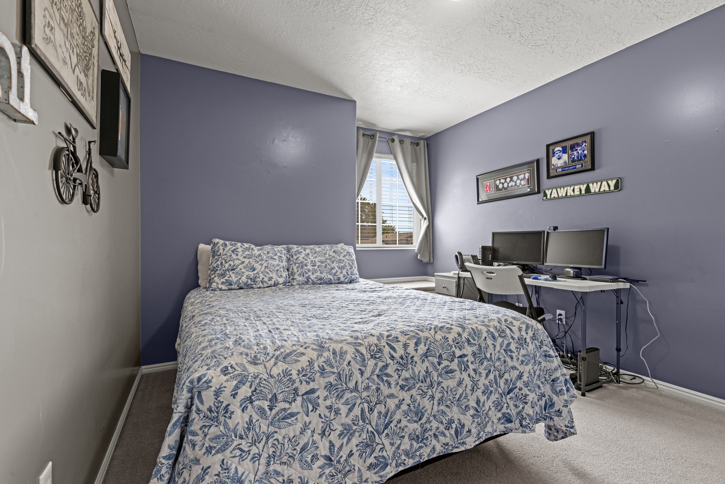 Carpeted room featuring a window with blinds and drapes, a built-in wall niche, and an overhead light fixture