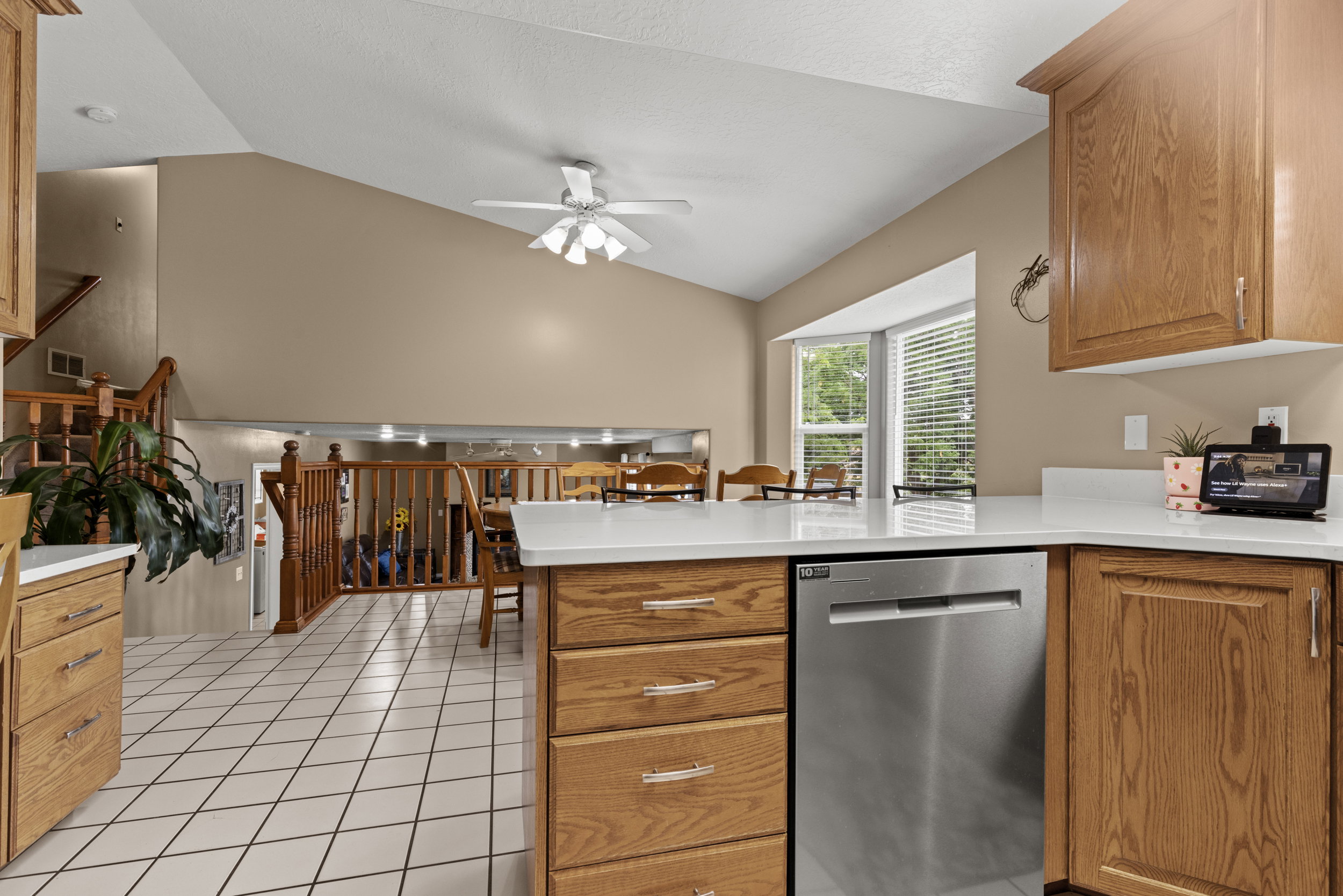 Kitchen featuring wood cabinetry, white countertops, and a stainless steel dishwasher