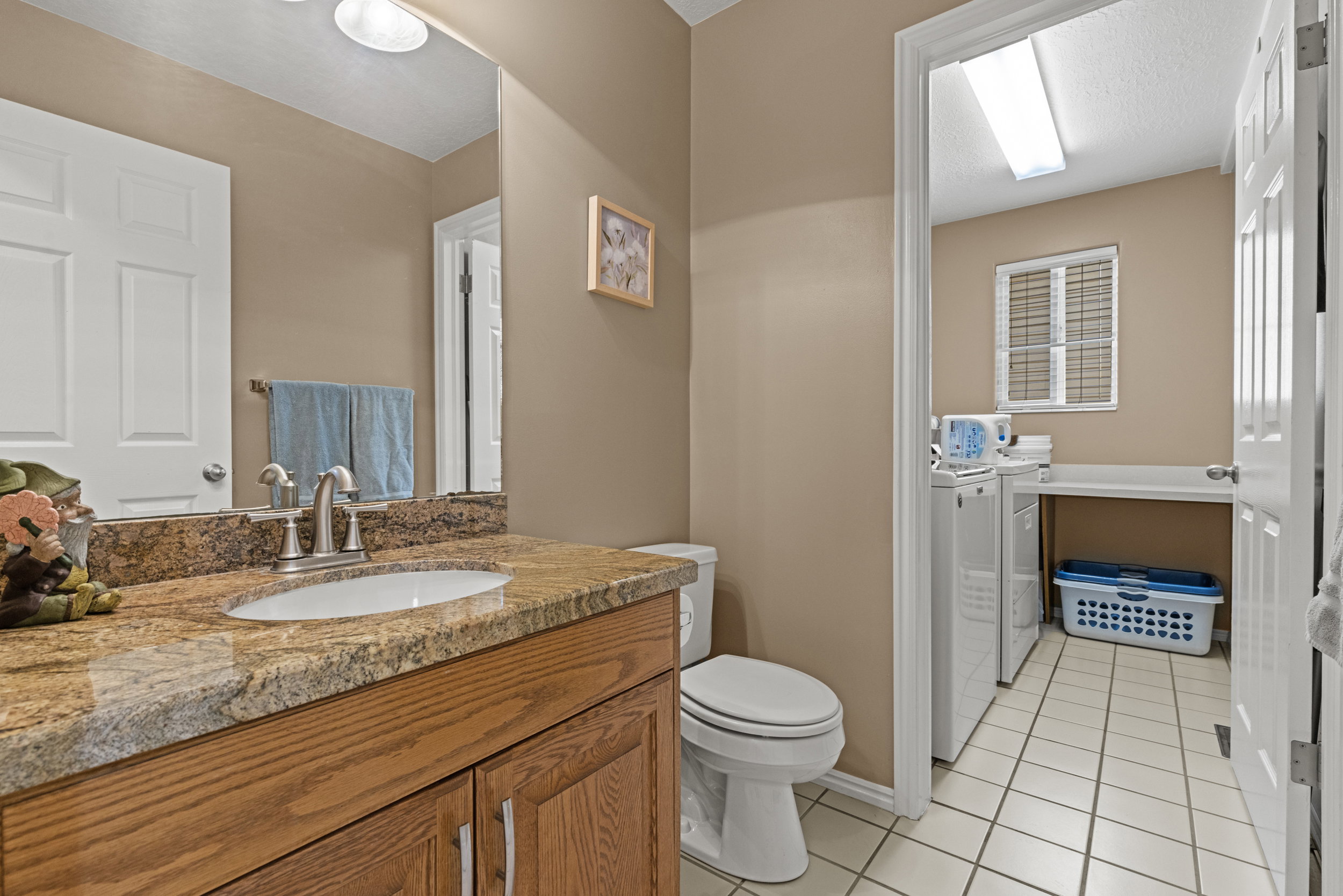 Bathroom featuring a vanity with a granite countertop, undermount sink, and brushed nickel faucet
