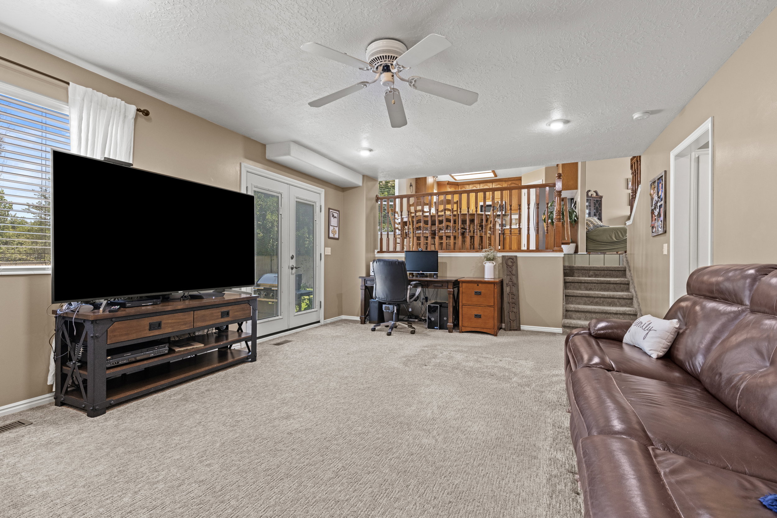 Lower-level living space featuring neutral carpet, a ceiling fan, and recessed lighting