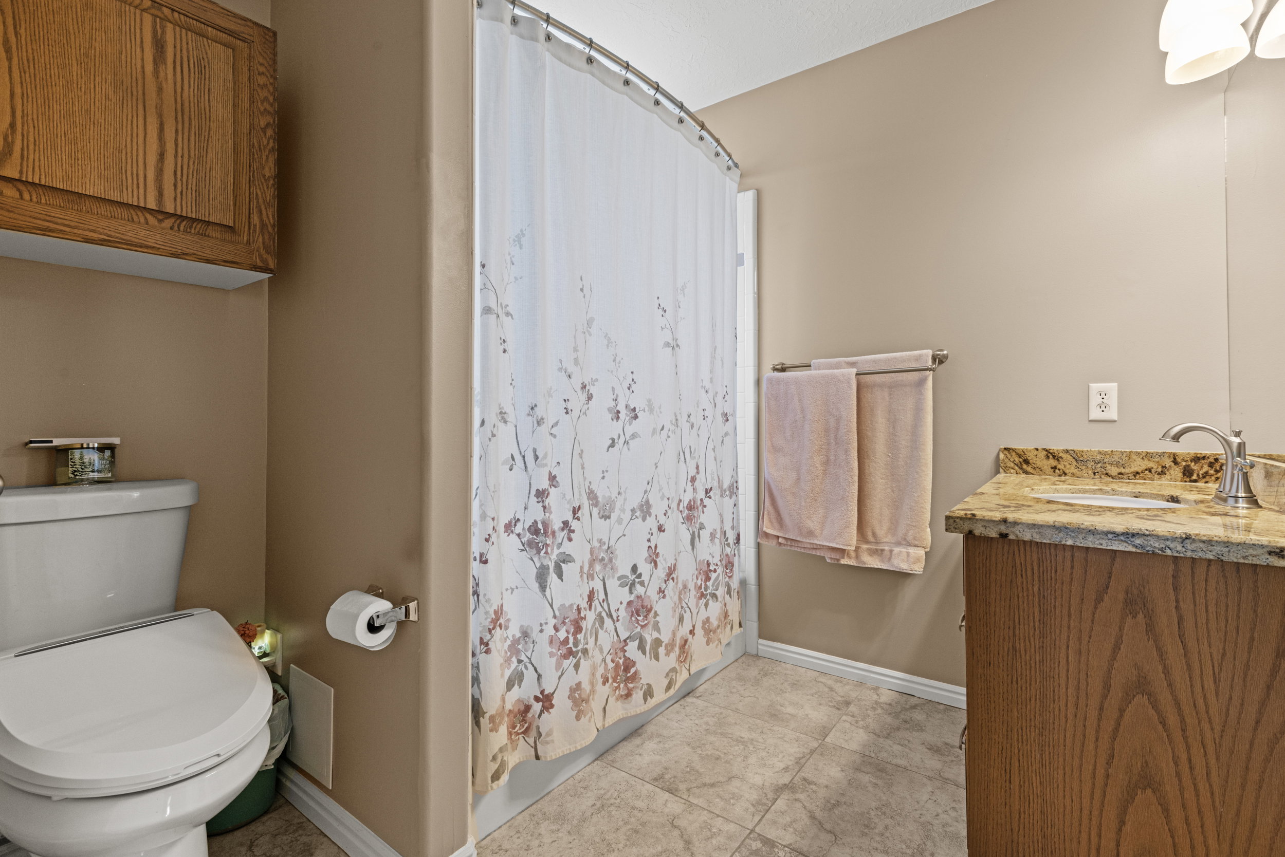 Bathroom featuring a vanity with a stone countertop and under-mount sink