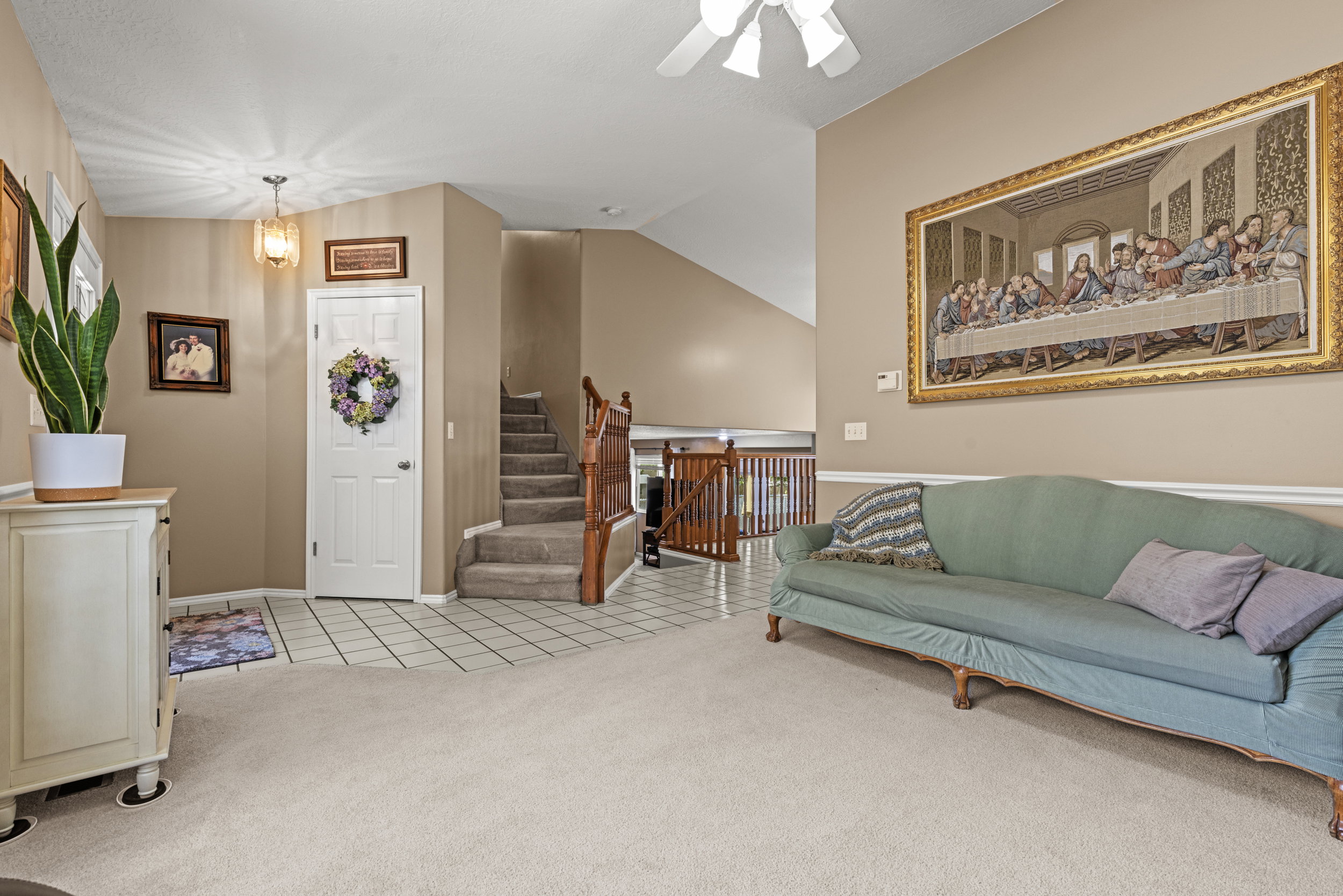 Entryway featuring light-toned tile flooring, a paneled door, and a decorative pendant light fixture