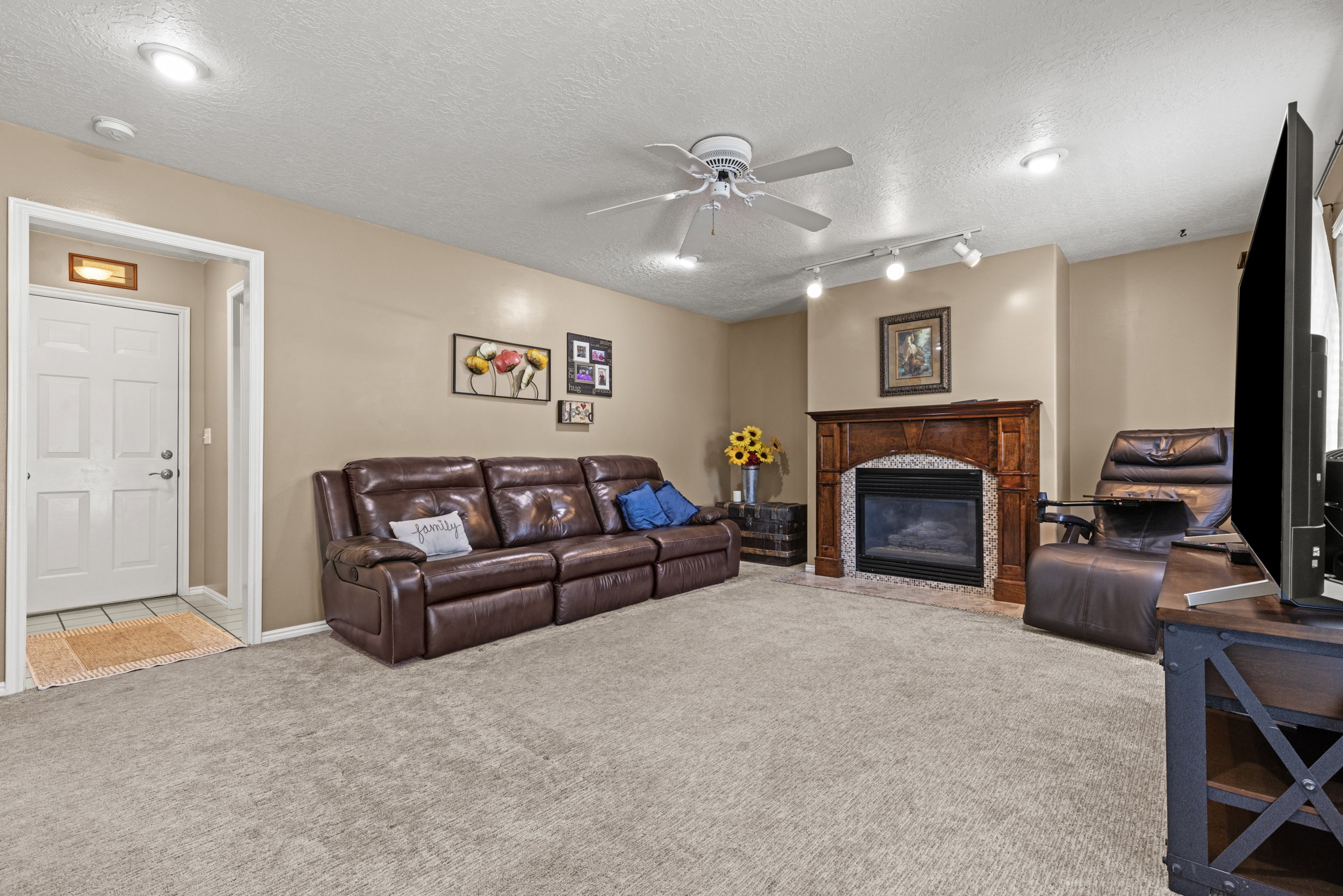 Living area featuring neutral wall tones, recessed lighting, and a ceiling fan