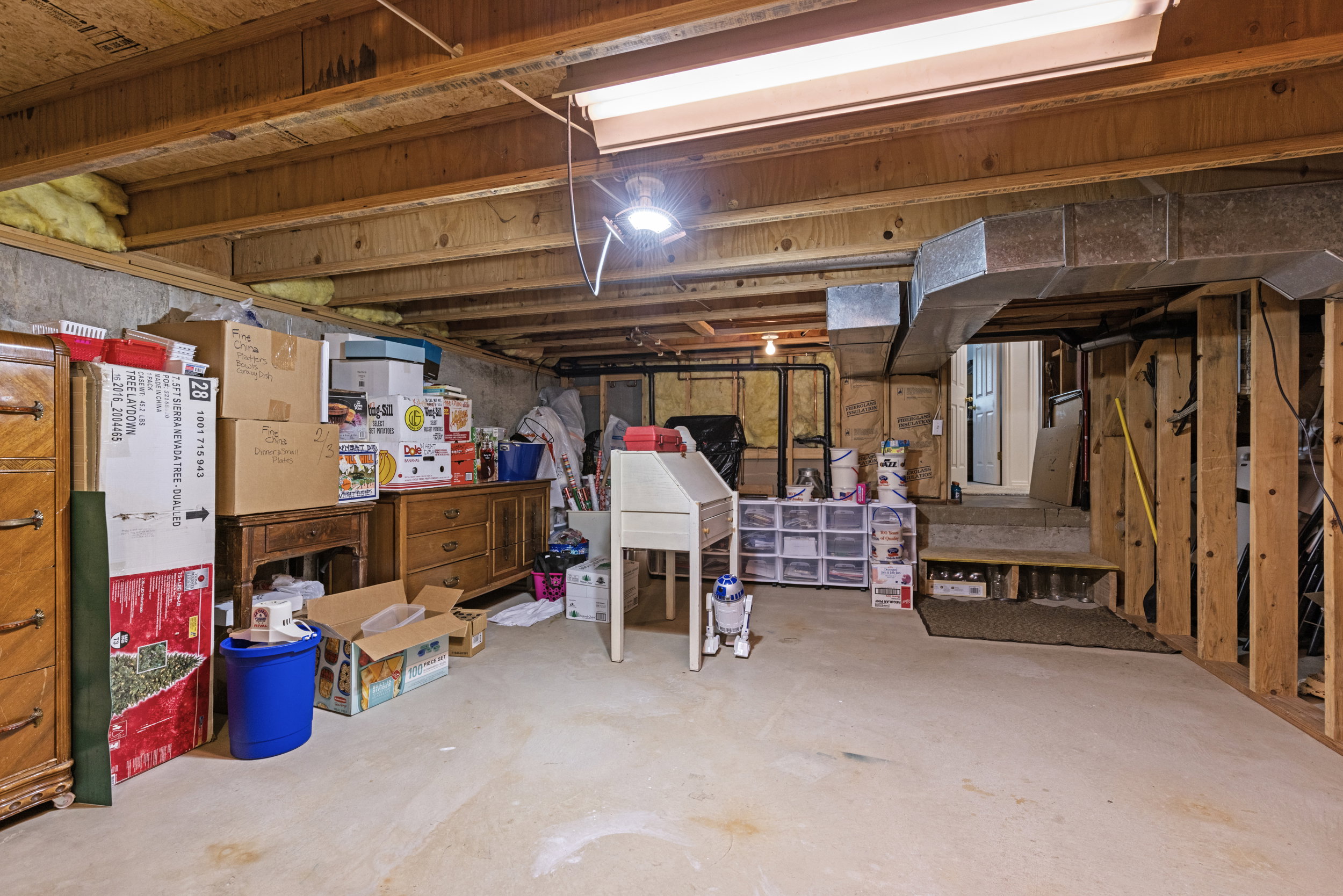 Unfinished basement featuring exposed wood joists, concrete flooring, and visible ductwork