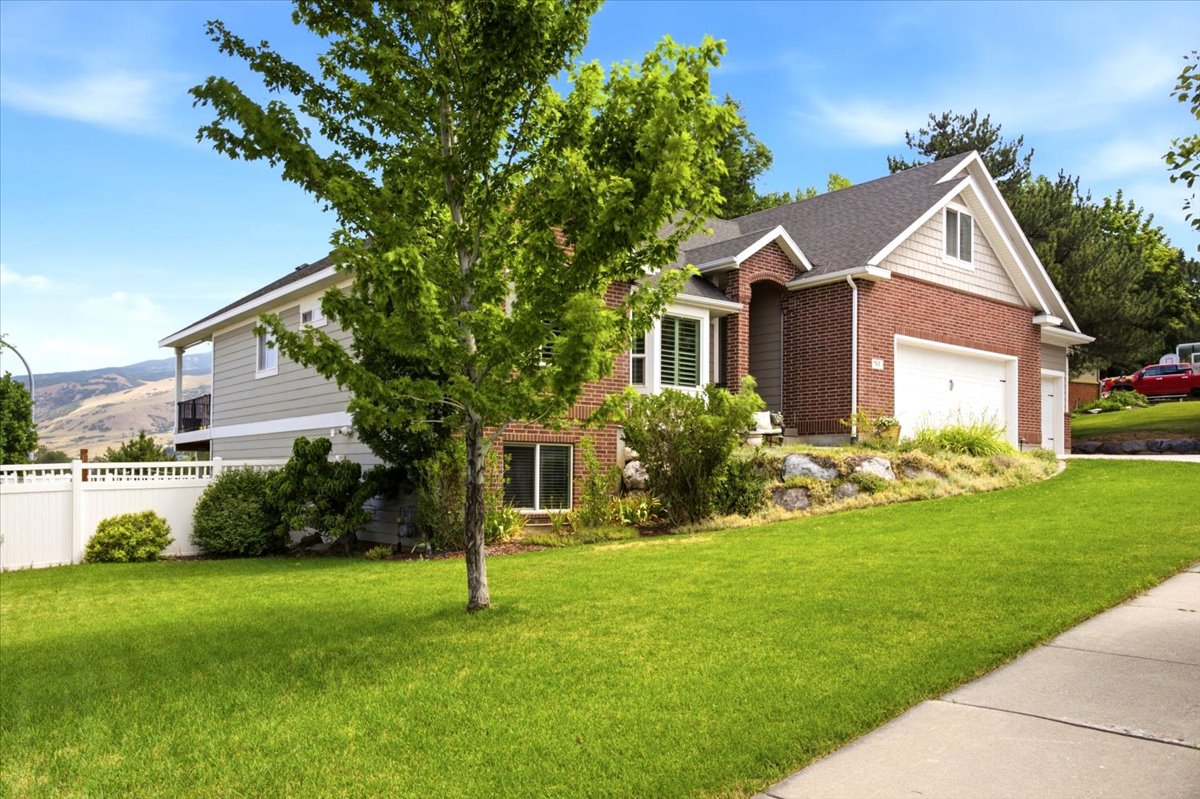Brick and siding exterior featuring an attached three-plus-car garage