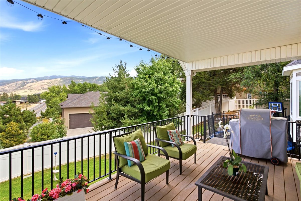 Covered deck featuring wood-finish flooring, black metal railing, and a slatted ceiling