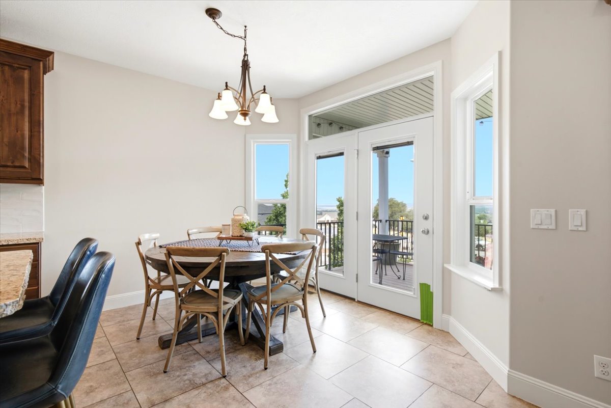 Dining area featuring tile flooring, a chandelier fixture, white baseboards, and a double-door exterior exit with windows