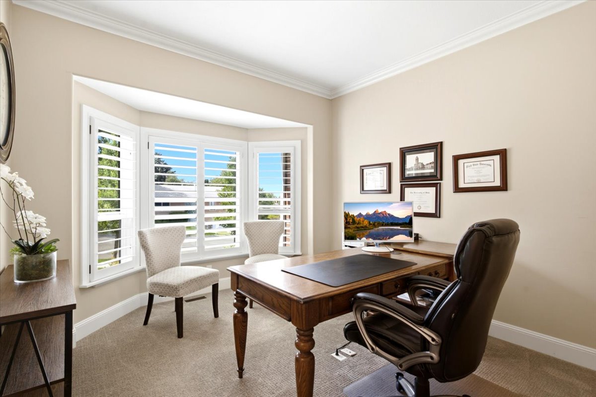 Front office bay window with white plantation shutters