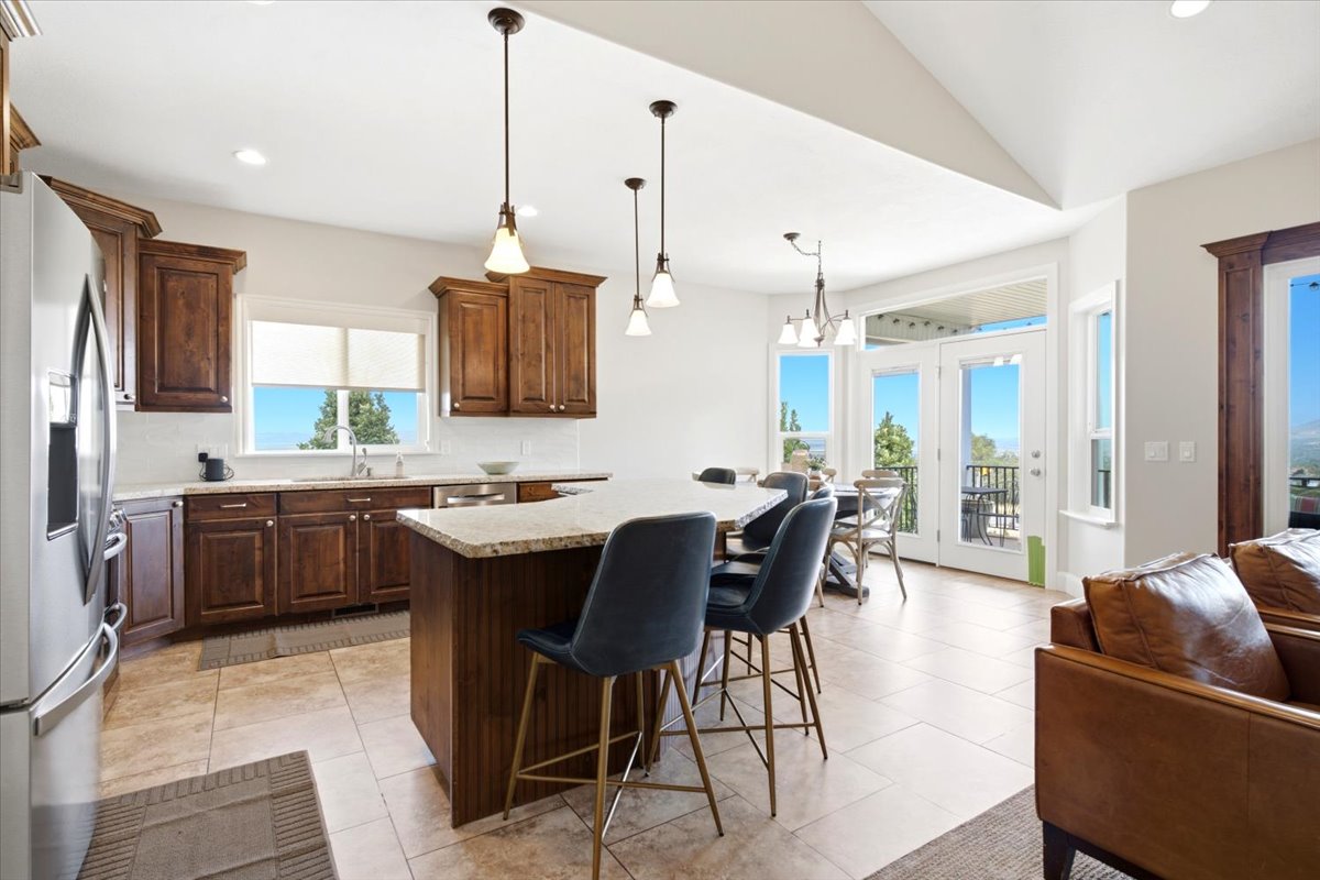 Open-concept kitchen featuring wood cabinetry, light-toned countertops, and a center island with bar seating