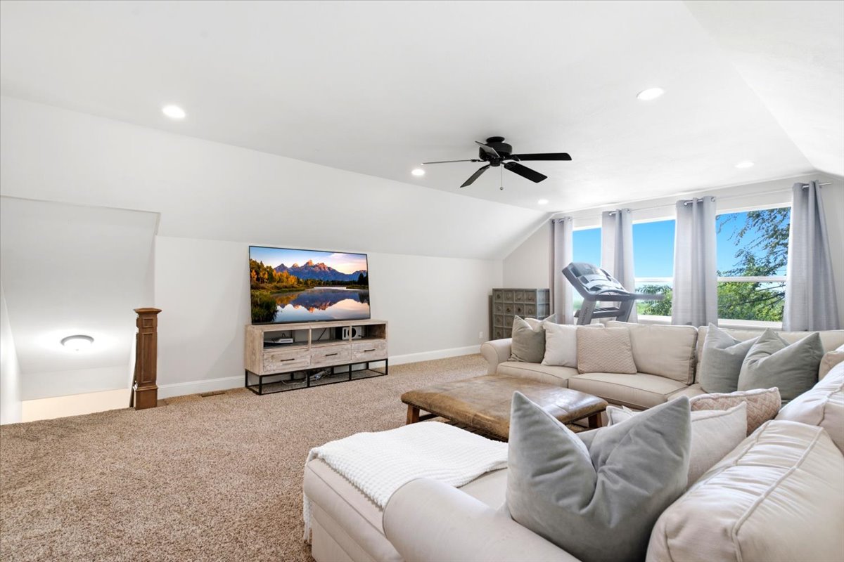Spacious bonus room featuring vaulted ceilings, recessed lighting, a ceiling fan, large windows with incredible views, and carpeted flooring