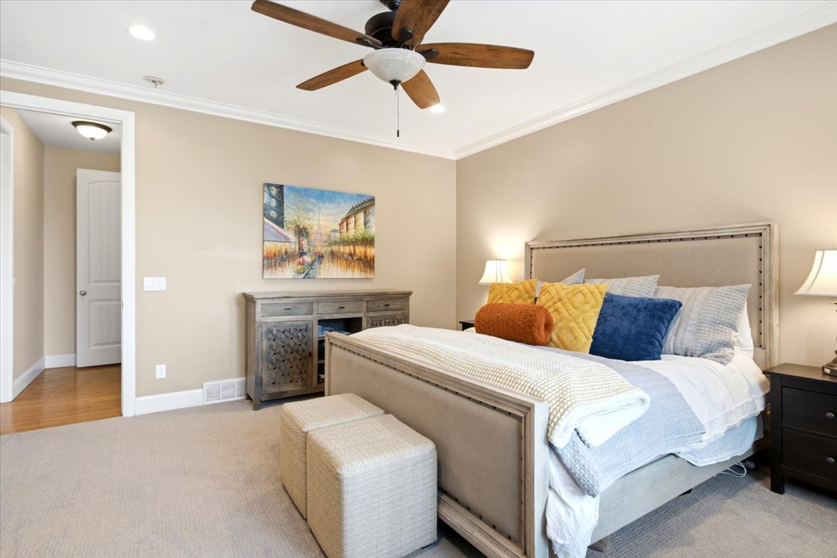 Spacious primary bedroom featuring a ceiling fan, recessed lighting, and crown molding