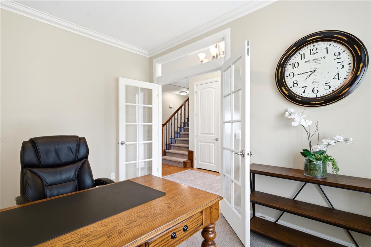 Interior French doors with glass panes, crown molding, and neutral wall paint