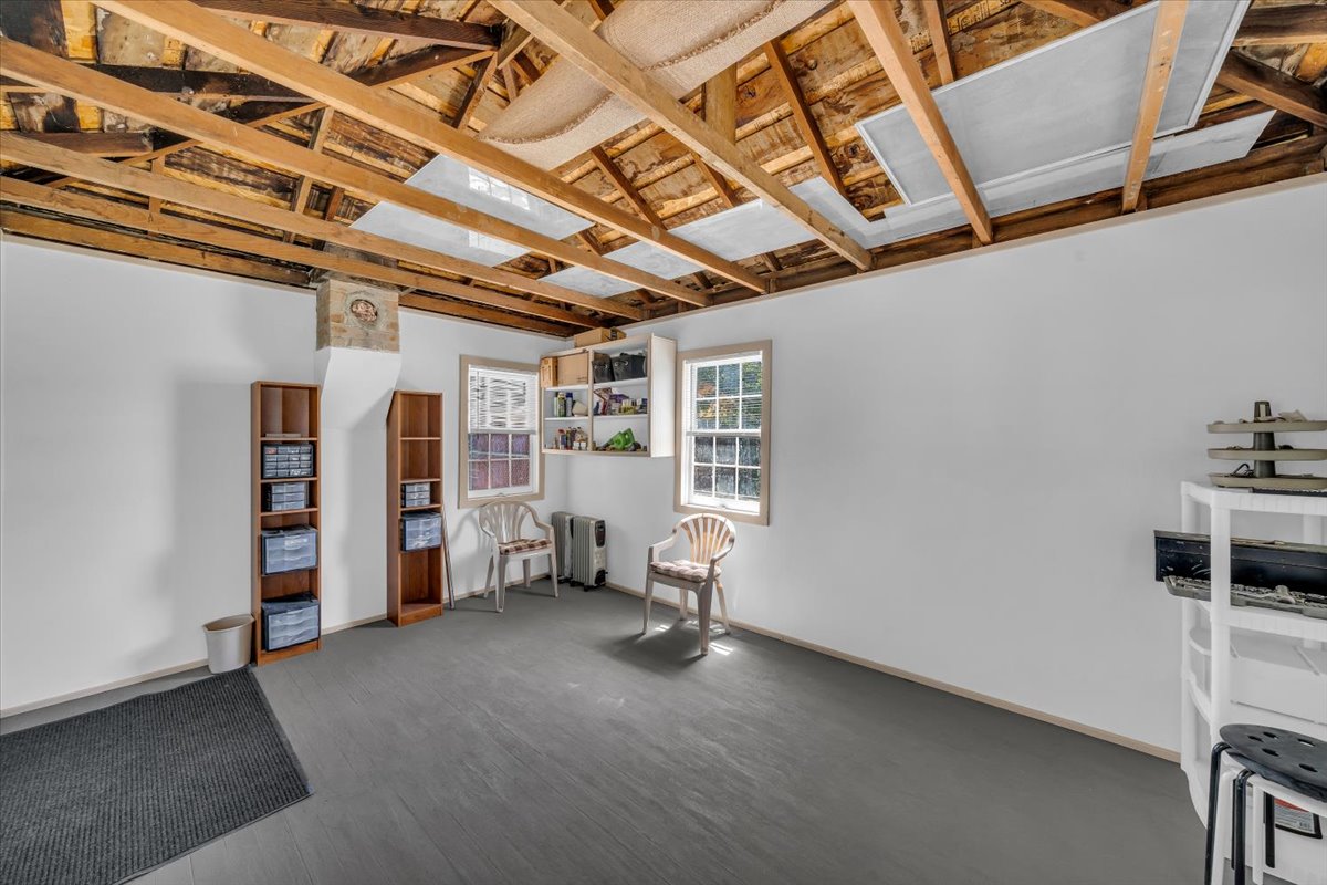Spacious room featuring white painted walls and a dark gray floor