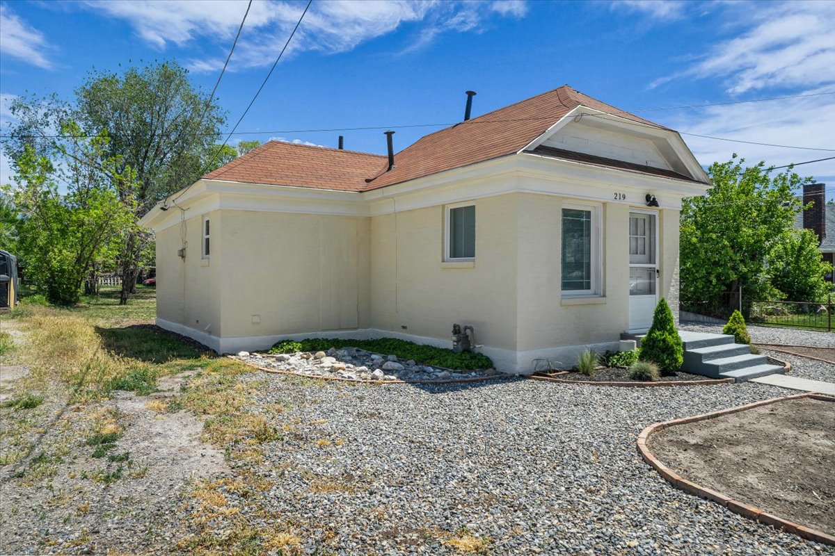 Cream-colored stucco exterior with a brown shingled roof