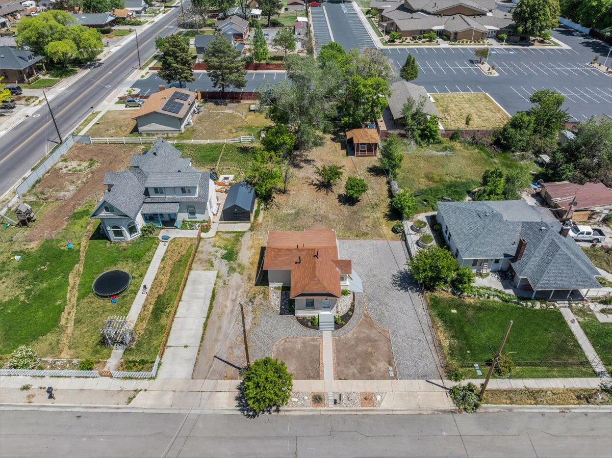 Aerial perspective showcasing three distinct properties, each with individual lot configurations and rooflines