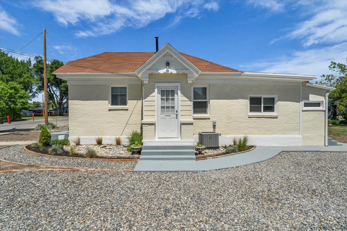 Charming single-story residence with a light-colored brick exterior and a reddish-brown shingle roof