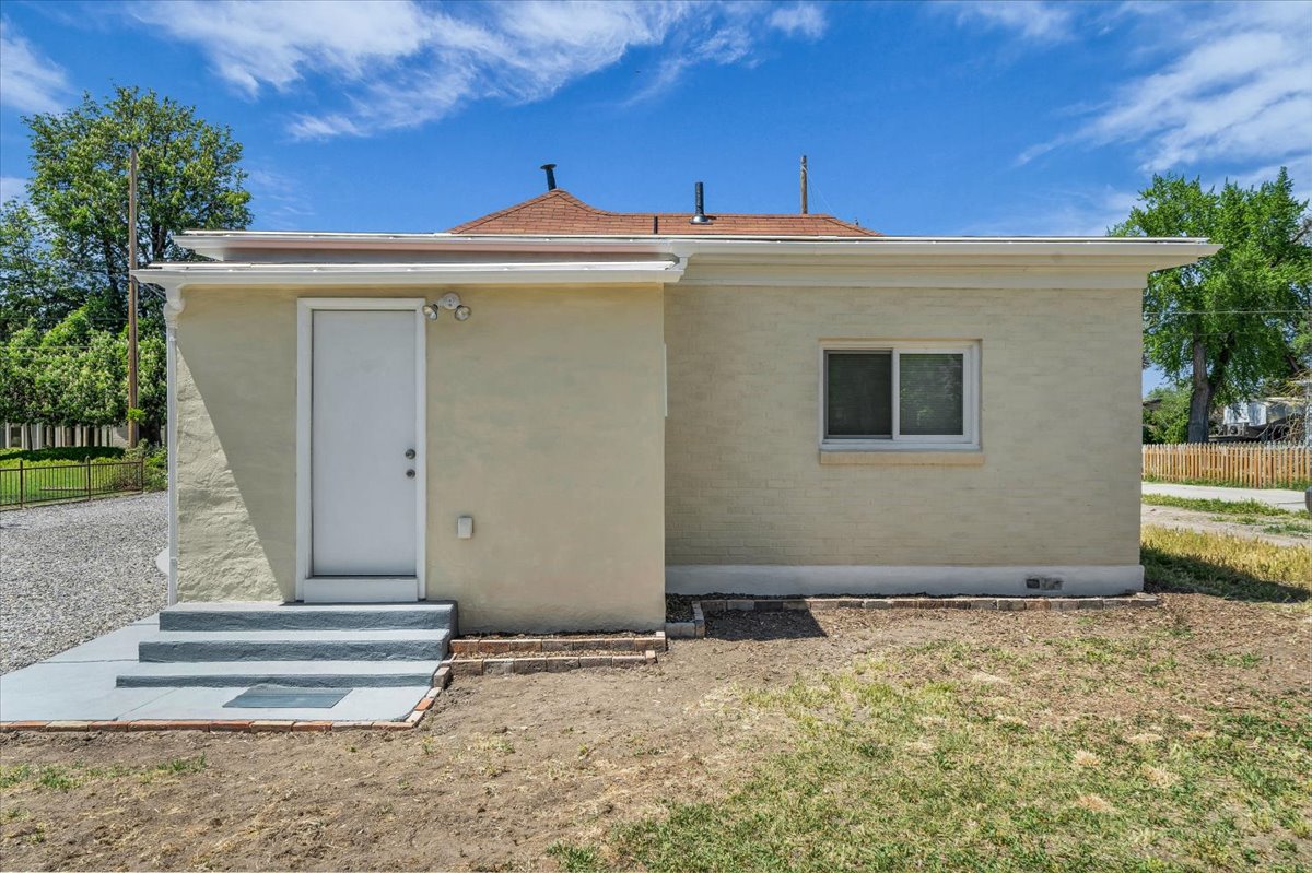 Stucco exterior with a white entry door and a single horizontal sliding window