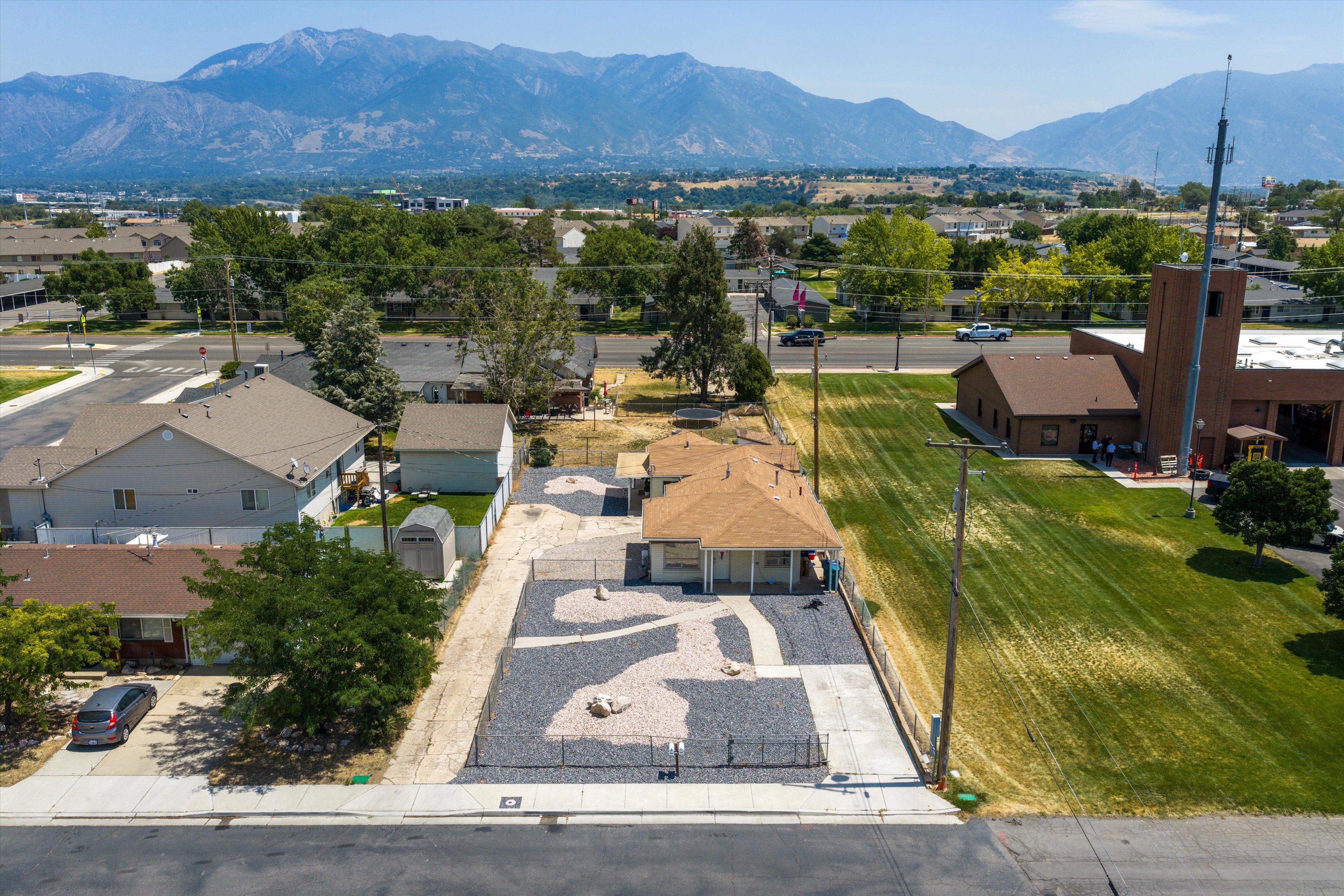 Ranch-style residence featuring a prominent pitched roof and a rock-landscaped front yard with a decorative path