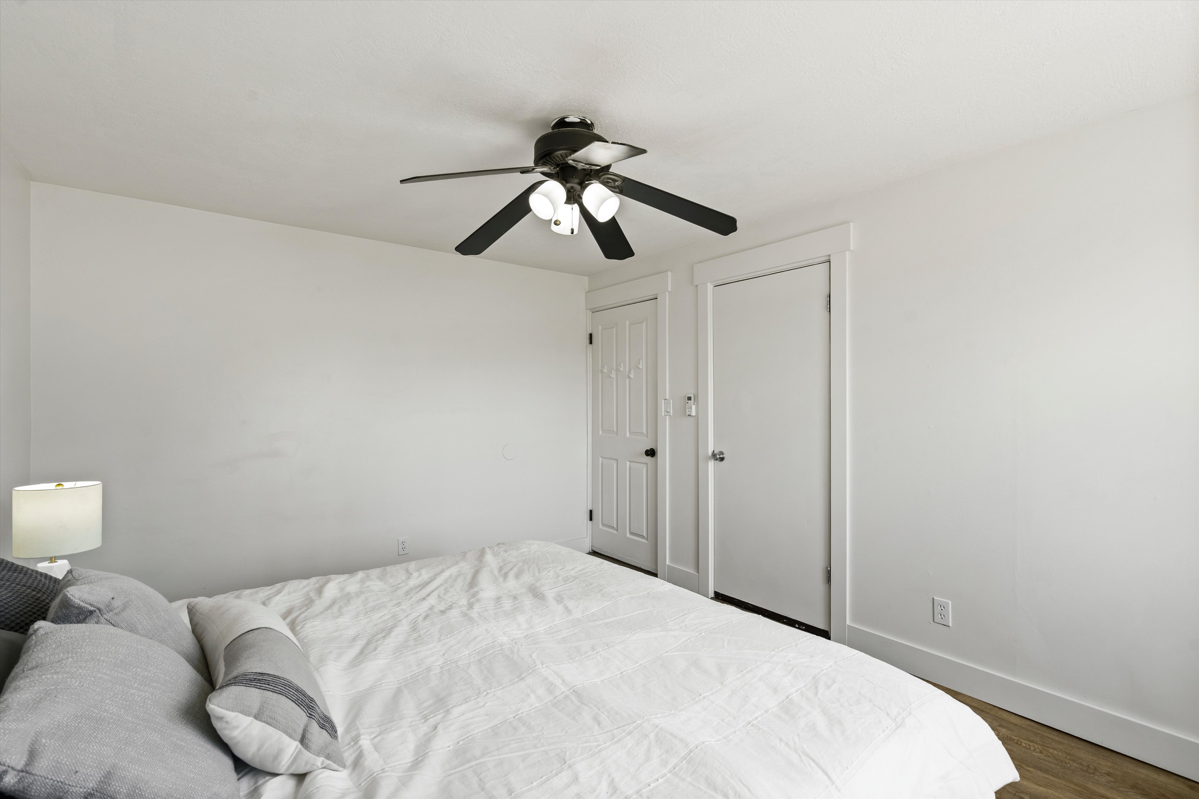 Bedroom featuring white walls and wood-finish flooring