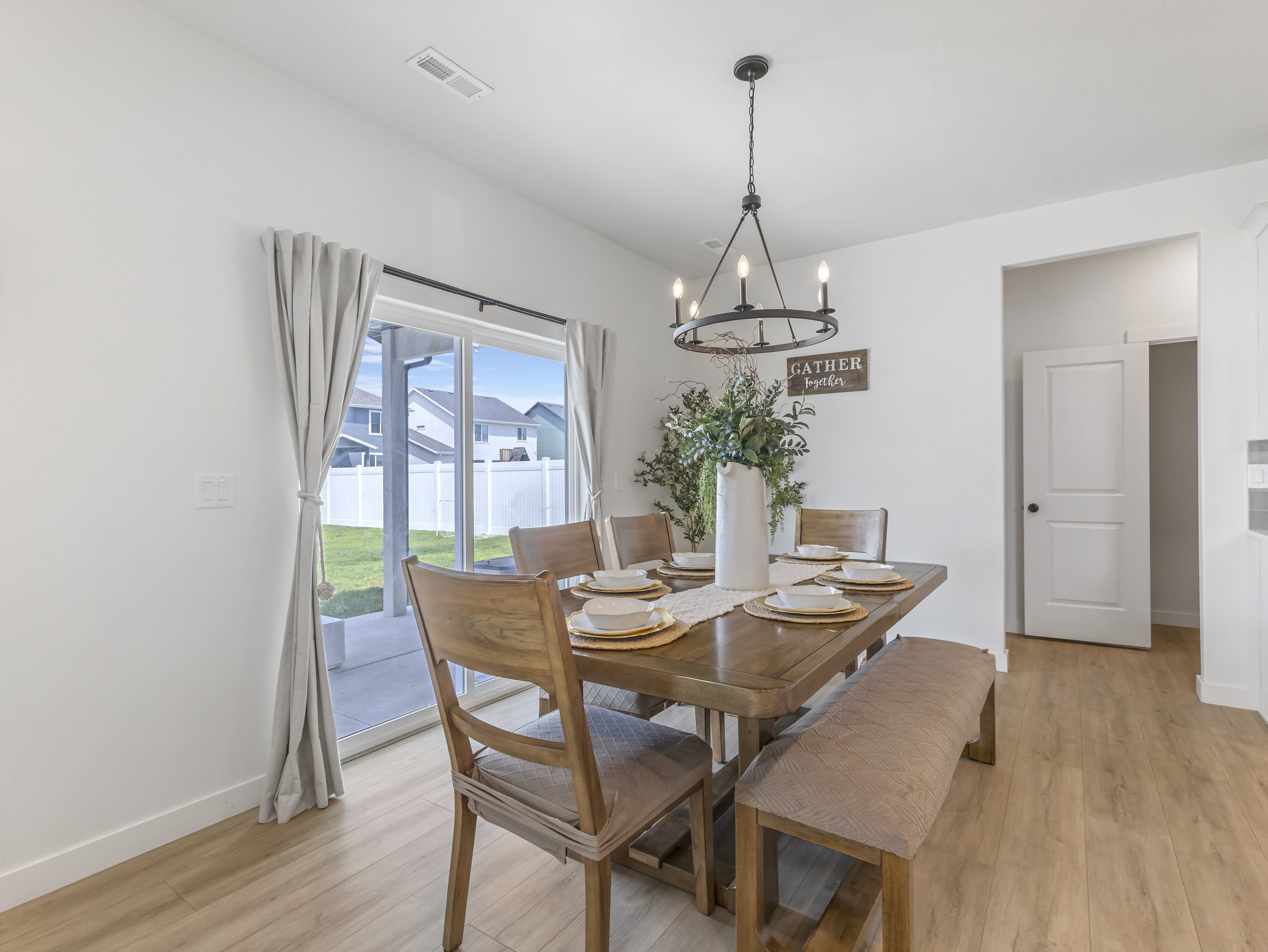 Spacious dining area featuring wood-finish flooring and a contemporary chandelier