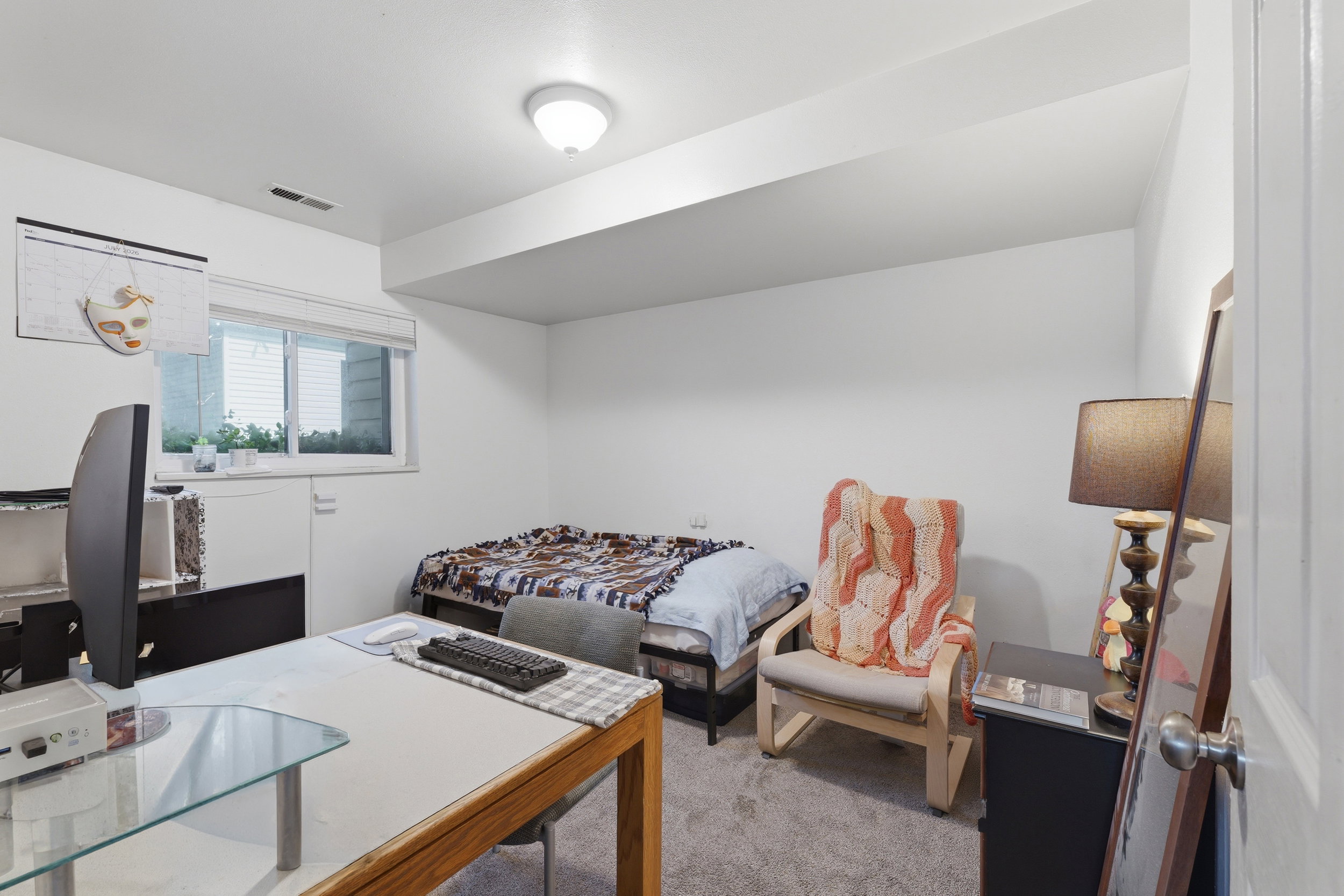 Carpeted room with a recessed window, white walls, and a ceiling-mounted light fixture