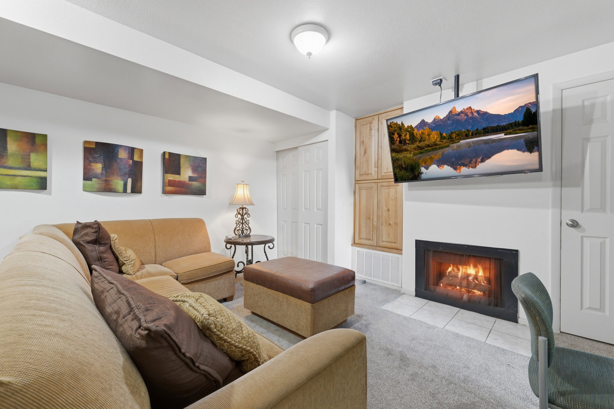 Recreational space featuring a built-in fireplace with a tile hearth, carpeted flooring, and built-in wood-finish cabinetry